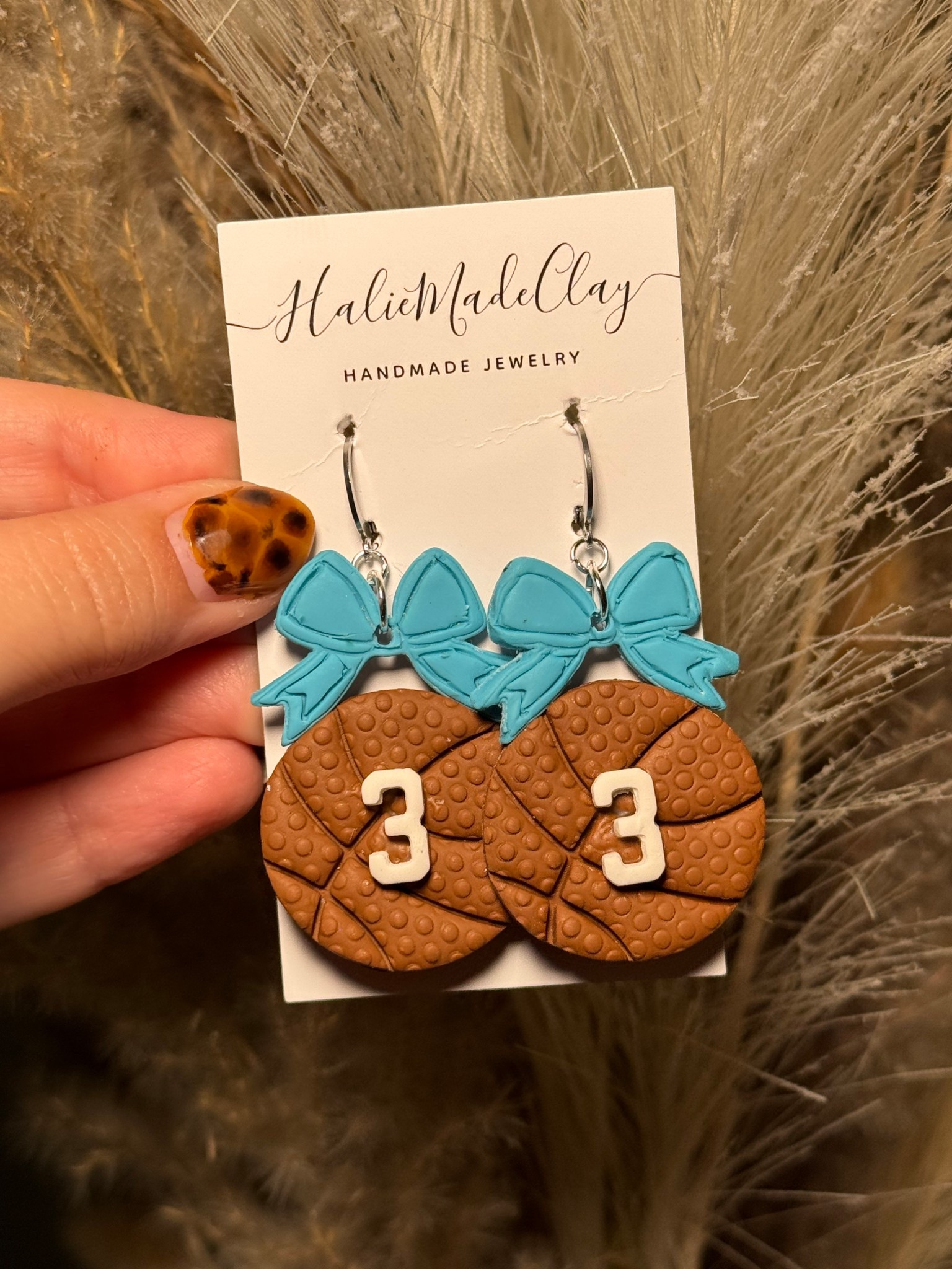 Celebrate your favorite player with these adorable Basketball Mom earrings! Handmade from lightweight polymer clay, these earrings feature a textured basketball design topped with a bow and your player’s custom jersey number. They’re the perfect accessory for game days, tournaments, and proud basketball moms who love to show off their team spirit.

🏀 Why You’ll Love Them:
	•	Customizable jersey number (your player’s number!)
	•	Bow color options to match team colors
	•	Lightweight polymer clay for comfort
	•	Handmade with love for basketball families

💝 Perfect Gift For:
	•	Basketball moms & grandmas
	•	Coaches & team moms
	•	End-of-season thank-you gifts
	•	Proud supporters at every game

#LTKKids #LTKGiftGuide #LTKSeasonal