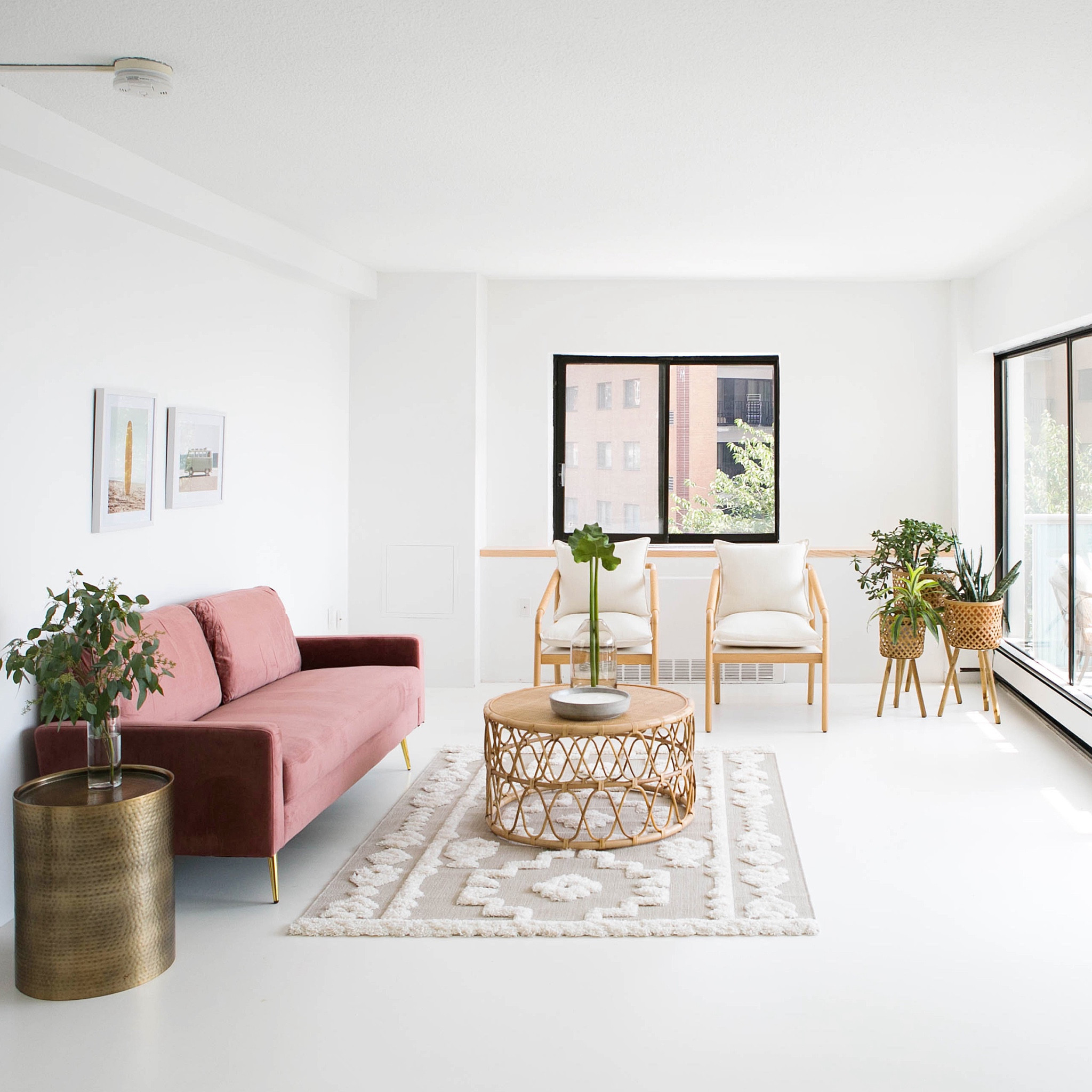 here's a wider shot of the living room at the #goldengirlscondo! we were inspired to incorporate a lot of natural rattan and light wood elements to complement the white paint. we also introduced a bit of color with this fun pink velvet couch and added some metallic accents for a bit of sparkle. #dwelloctober 

#LTKhome