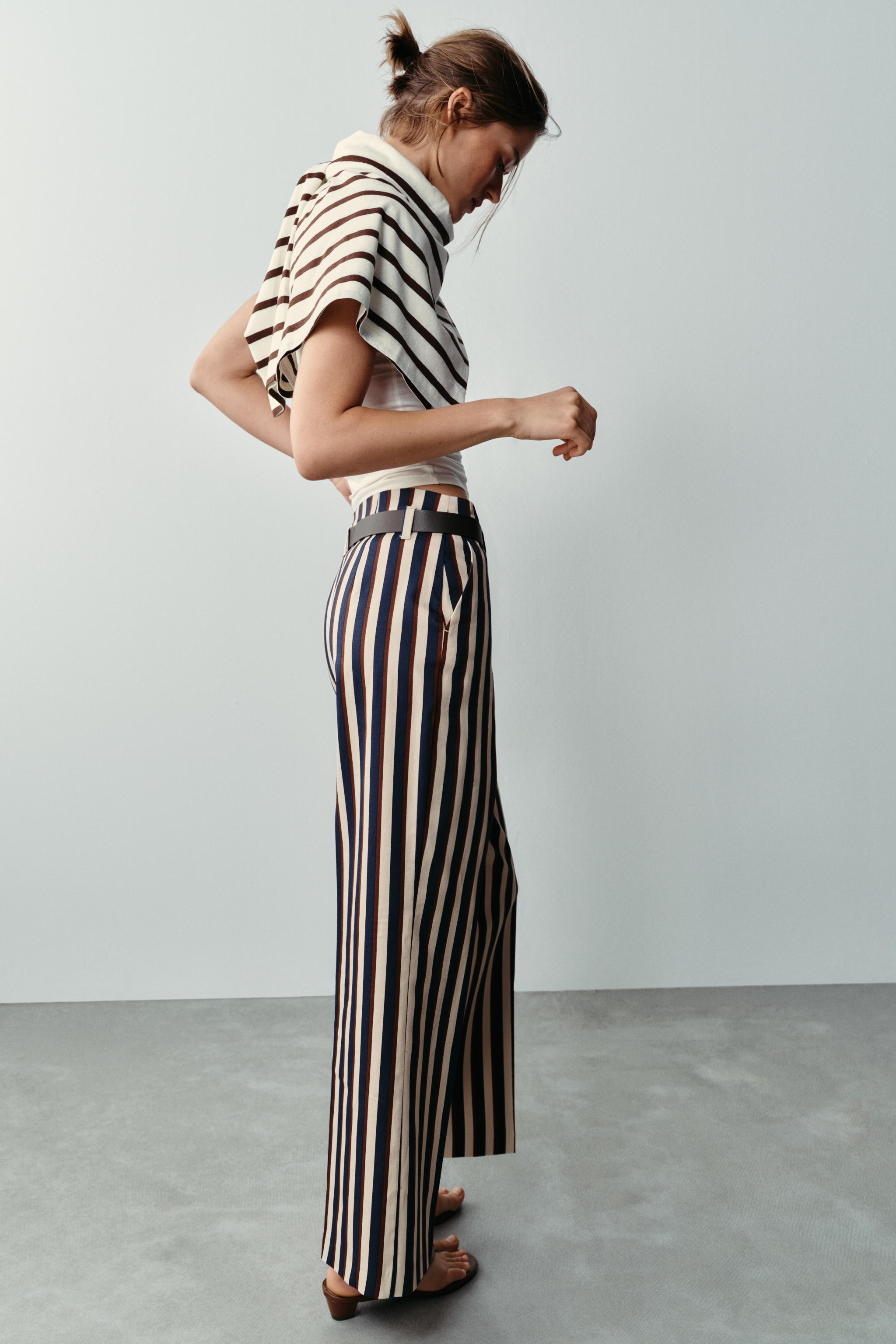 High-waist trousers with front pockets. Featuring a belt detail, straight leg, and front fastenin... | Zara UK