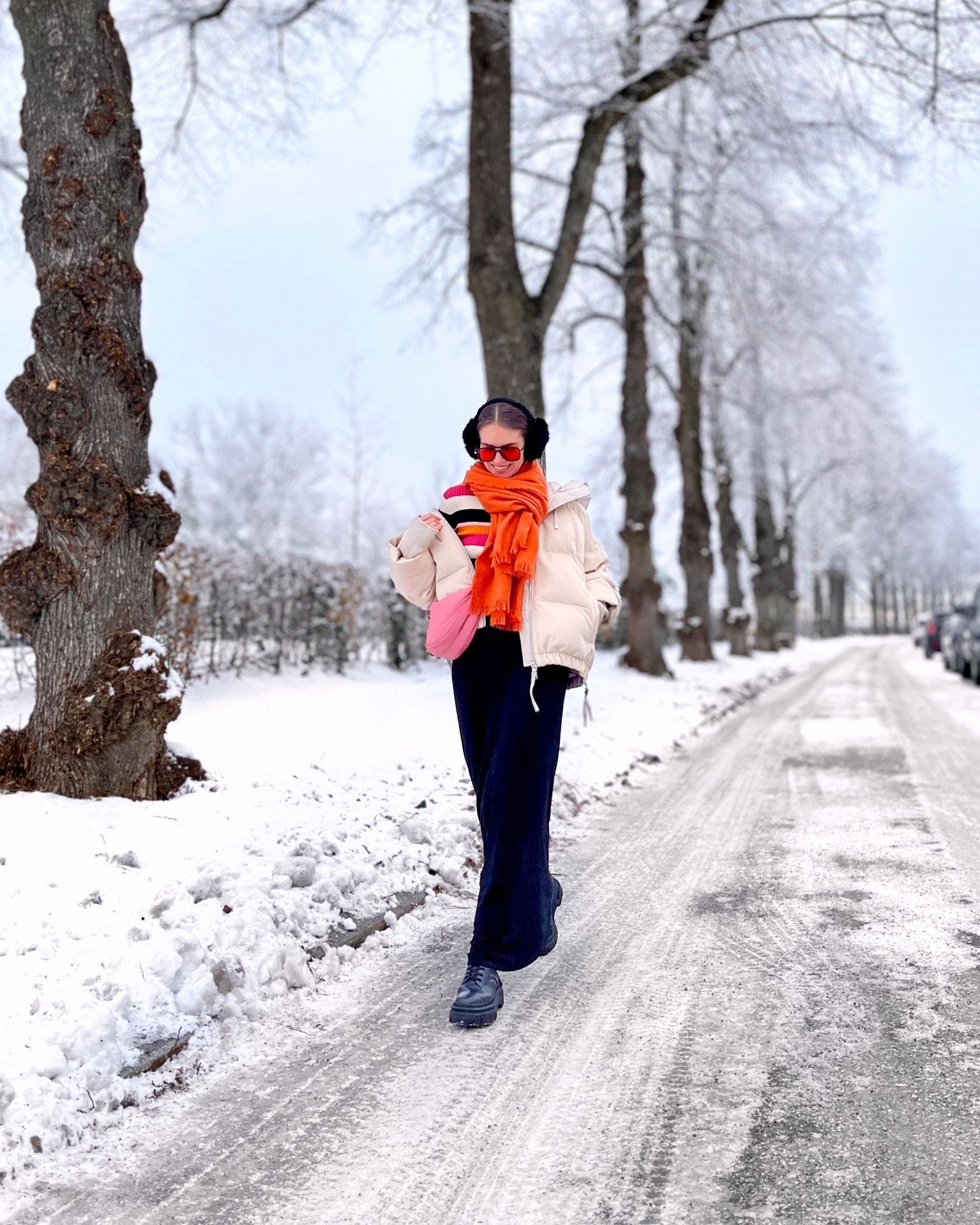 Blonde girl in daily street style wearing color. Pink and orange outfit. Maxi skirt, down jacket, striped sweater, ear muffs and chunky boots. #colorfuloutfit #colorfulstyle #colorfulfashion #colorfullooks #fashionfun #cutewinteroutfit #winterfashion2023 #winterlookbook #fitcheck #dailylooks #dailylookbook #contentcreator #microinfluencer #discoverunder20k