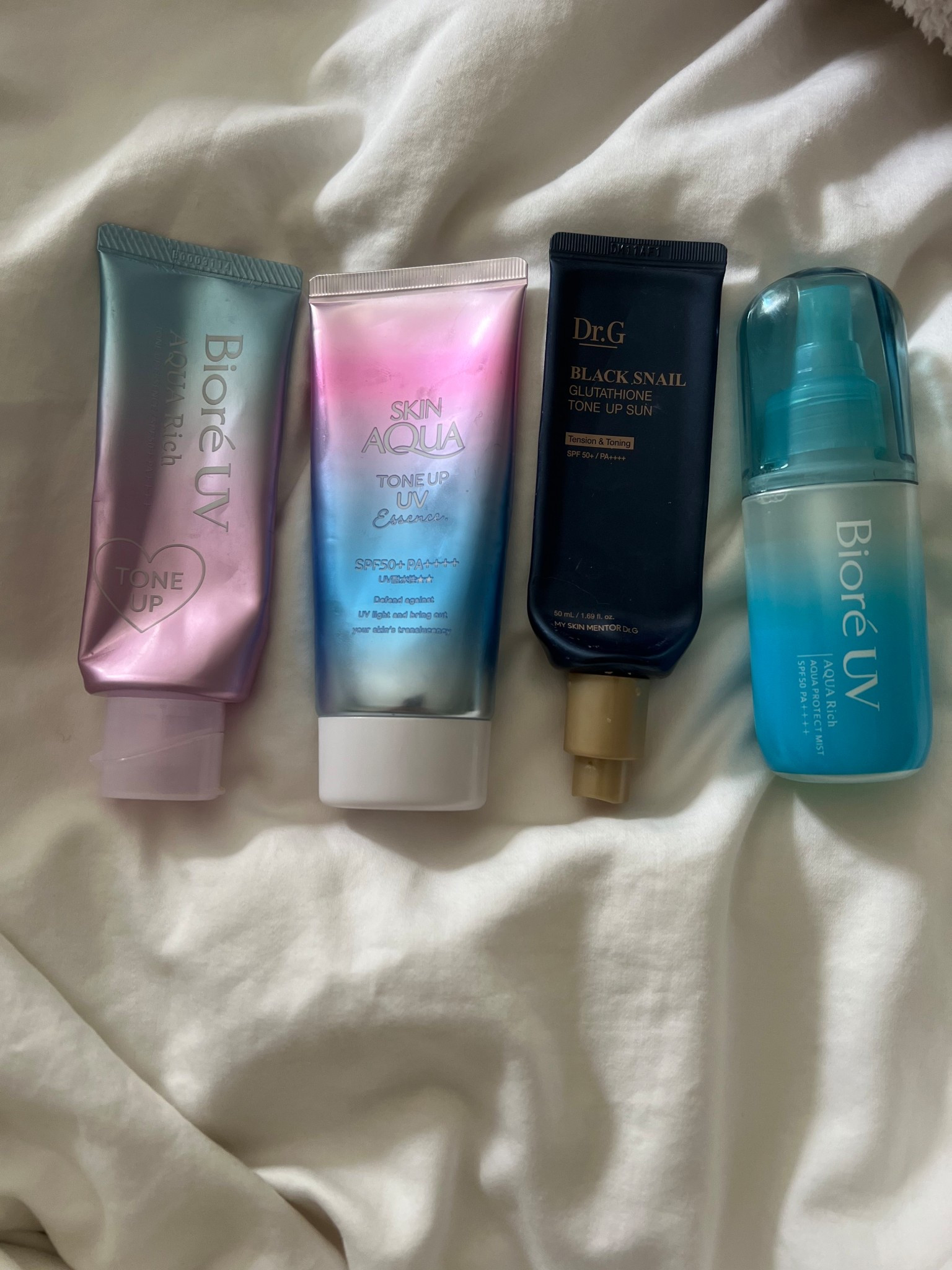✨ My Favorite “Tone-Up” Sunscreens Right Now ✨

I just got back from Tokyo, and while I was there, I probably tried 20 different sunscreens (yes, really!). Out of all of them, these are the ones that stood out and actually earned a permanent spot in my routine.

1. Biore UV Aqua Rich Tone Up (lavender tube)
	•	Lightweight, watery texture that sinks in instantly.
	•	Leaves skin looking brighter and more even, without any heavy residue.
	•	Like most Biore sunscreens, this one works beautifully on all skin tones—no white cast.
	•	Absolutely zero “sunscreen smell,” which is a big win.

2. Skin Aqua Tone Up UV Essence (pink + blue tube)
	•	Similar to the Biore in texture: thin, hydrating, and easy to layer under makeup.
	•	Adds a subtle radiance to the skin—perfect for that natural glow.
	•	Again, very inclusive: no noticeable cast even on deeper skin tones.

3. Dr. G Black Snail Glutathione Tone Up Sun (black tube)
	•	A little heavier, with more of that classic tone-up finish.
	•	Important note: while it gives a brightened, smooth look on lighter skin tones, it’s not ideal for darker skin because it can leave a visible white cast.
	•	Works best as a primer-type base if you want a slightly more “polished” look under makeup.

4. Biore UV Aqua Rich Aqua Protect Mist (blue spray bottle)
	•	Ultra-light mist that makes reapplication ridiculously easy.
	•	No sticky finish, no white cast, and still gives that subtle brightening effect.
	•	Perfect for mid-day touch-ups over makeup or while on the go.

⸻

✨ Overall Thoughts ✨
After testing so many formulas in Tokyo, these are the four that actually impressed me. Biore sunscreens remain the most versatile—perfect for deeper skin tones, lightweight, and no cast. The Dr. G Black Snail is beautiful but best for fair to medium tones. And the best part? None of these formulas have that dreaded sunscreen smell.