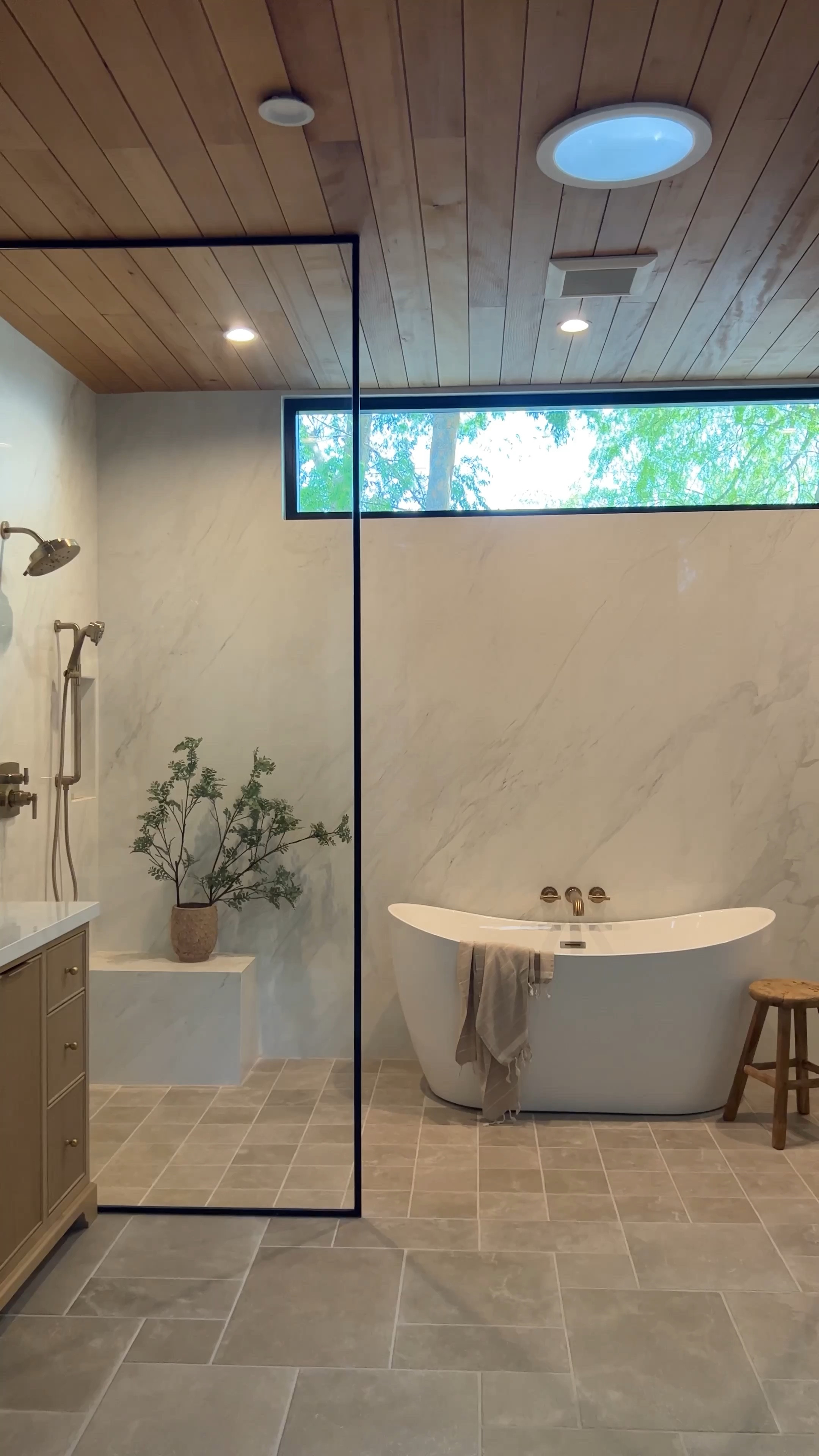 Bathroom design. Faux branches, green branches, eucalyptus leaves, striped towel, white tub, soaking tub, marble tile, wood vanity, brass faucet, brass, plumbing, stripe towel. wooden stool, nail vase, shower, glass door floor tile limestone tile. Rectangle mirror, black mirror medicine cabinet. Wayfair Amazon.

#LTKFindsUnder100 #LTKHome #LTKSaleAlert