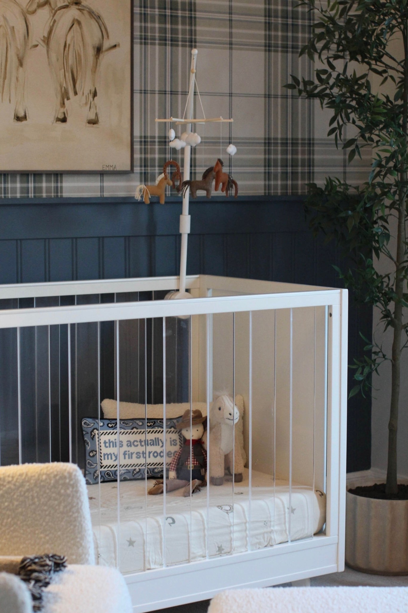 welcome to our little cowboy’s cozy corner, where western charm meets baby dreams ✨🤠

designer: @gather_in_grace
art: @emma_katherineart 
chandelier: @laurieshomefurnishings
wallpaper: “haberdashery westley plaid wallpaper - moss” from @uswalldecor 
paint color: SW “needlepoint navy” and SW “egret white”

nursery inspo, baby boy nursery, western chic, baby, newborn, wallpaper, home inspo, kids room, cowboy, home interior 

#LTKBaby #LTKstorytime #LTKHome