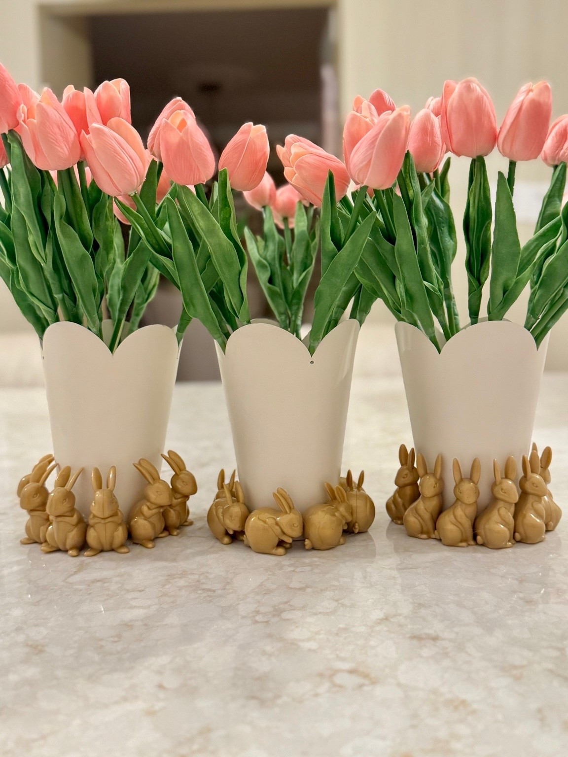 Spring styling made simple 🌷🐰
These sweet tulip arrangements instantly brighten any space and give the cutest Easter touch without any fuss. I paired soft pink faux tulips with scalloped white vases and added the most adorable bunny detail around the base for a playful, elevated look.

Perfect for kitchen counters, coffee tables, or as a quick hostess-ready centerpiece. It’s one of those “looks high-end but took minutes” kind of decor wins 💕

Everything is linked to recreate this easy spring moment!

#LTKhome #LTKspring #LTKeaster #easterdecor #springdecor #homedecorinspo #eastercenterpiece #springcenterpiece #kitchenstyling #coffeetabledecor #neutralhome #easterbunnies #fauxflorals #simpledecor #eleganthome #seasonaldecor #liketkit #ltkfinds #homesweethome #eastervibes