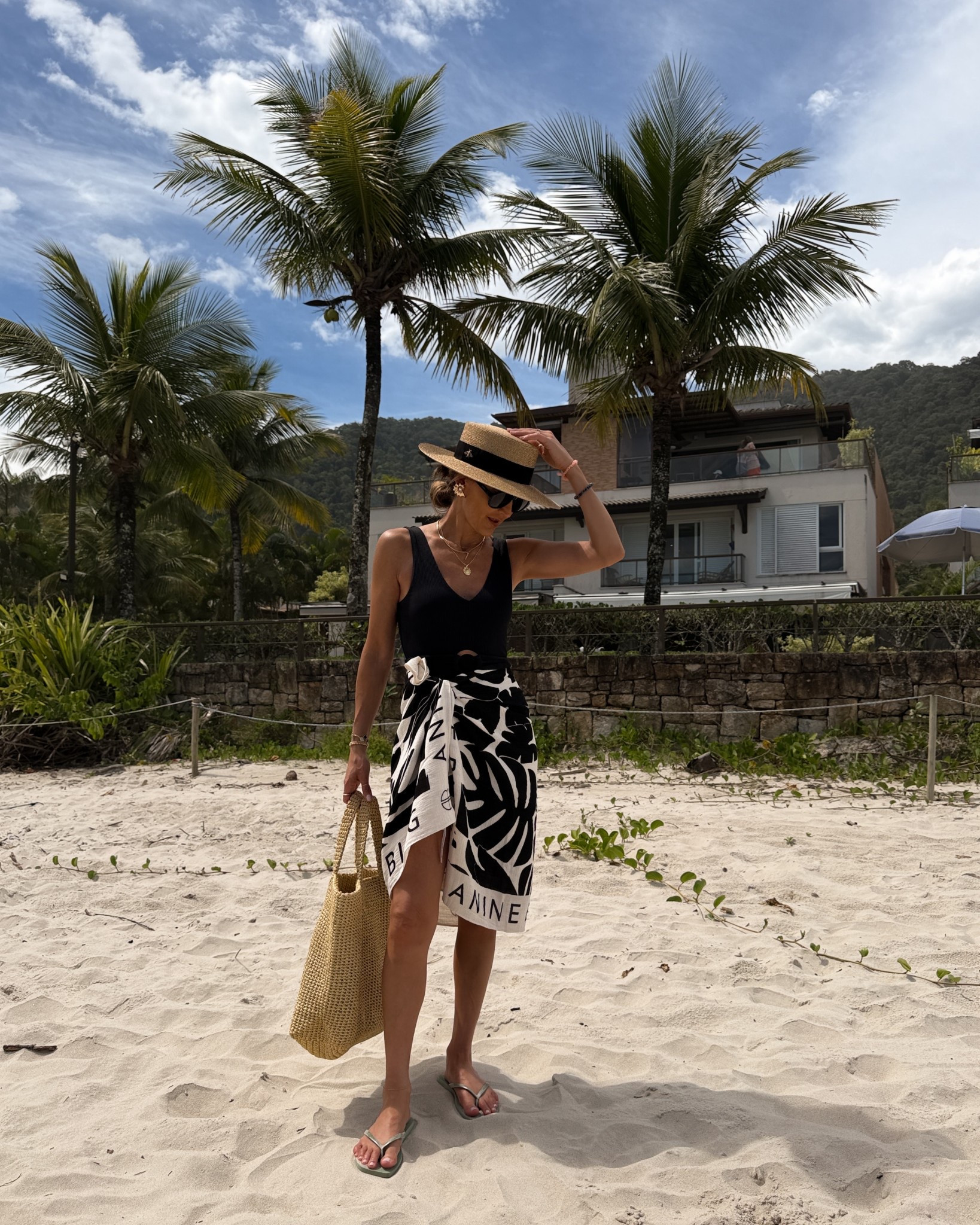 Chic Beach Fit 🖤🤍☀️ comment BEACH OUTFIT and I’ll dm you the links to shop! 

One piece rib knit bathing suit, black and white sarong, boater hat, large Prada crochet bag, shell earring, chic beach outfit 

#LTKOver40 #LTKSeasonal #LTKTravel