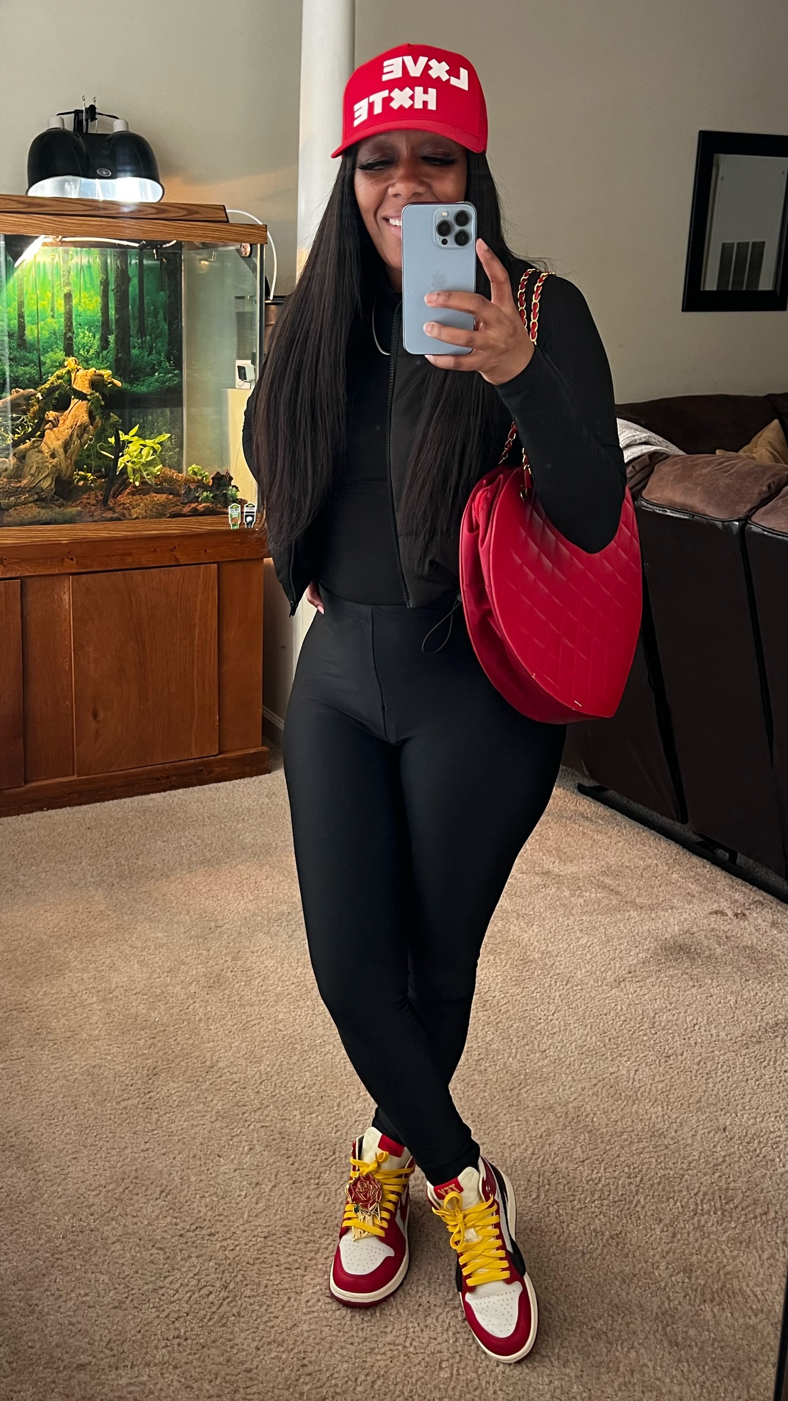 How to style an all black outfit. I’m wearing a black long sleeve bodysuit, black leggings, and a black puffer vest.
Outfit details: red hat with red heart shaped purse

#LTKitbag #LTKshoecrush #LTKstyletip