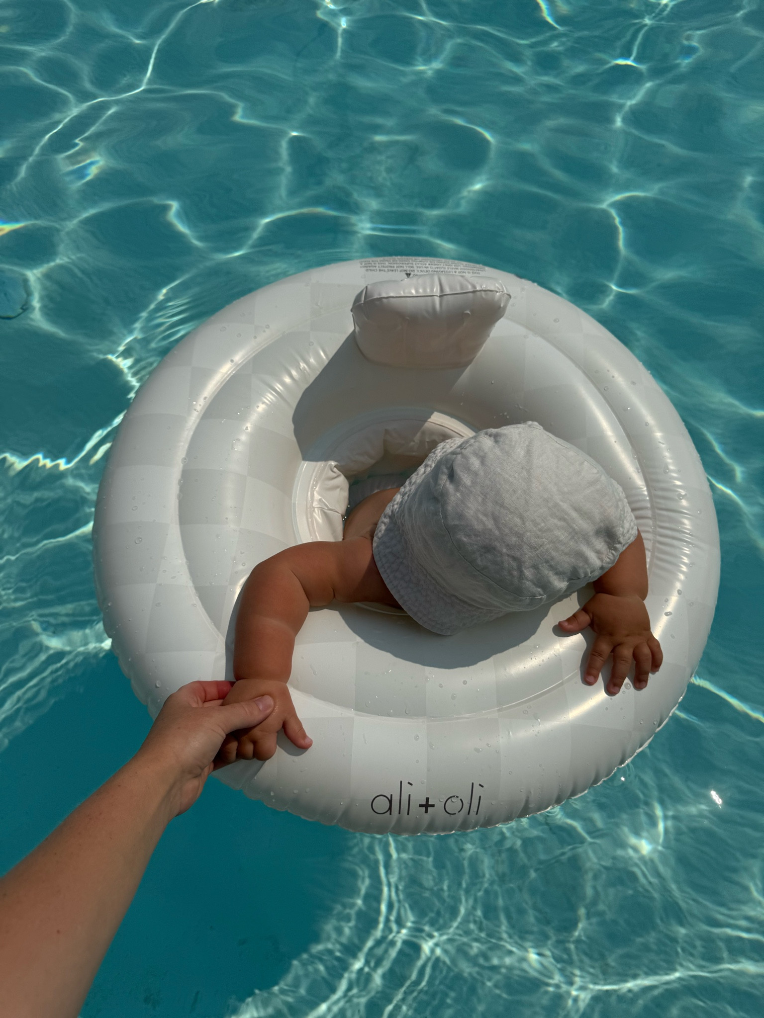 I would like to leave a sincere review for this inflatable baby float. I previously had a different inflatable float, but it didn’t provide enough stability. When my son, Leon, leaned forward to play with the water, he would often tip over, ending up headfirst in the pool.

The **Ali+Oli** inflatable float stands out with its thoughtful design and wide base, which securely keeps the child afloat, preventing any tipping. Additionally, the stylish and neutral design will appeal to many parents who appreciate aesthetics in baby products.

#LTKSwim #LTKSeasonal #LTKKids