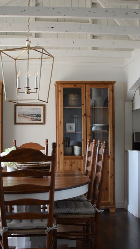Pine cabinets, vintage coastal art, ladder back dining chairs and a brass lantern over the antique dining table all do their part to add charm and character to our cottage dining room. 


#LTKHome #LTKVideo