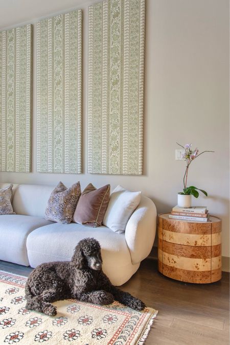 Apartment living room interior design with DIY fabric-covered wall panels, cream boucle performance sofa, burl wood side table, and floral wool area rug by Kevin Francis Design, living room styling, interior inspiration, green decor, curved sofa, classic interiors 

#LTKStyleTip #LTKHome