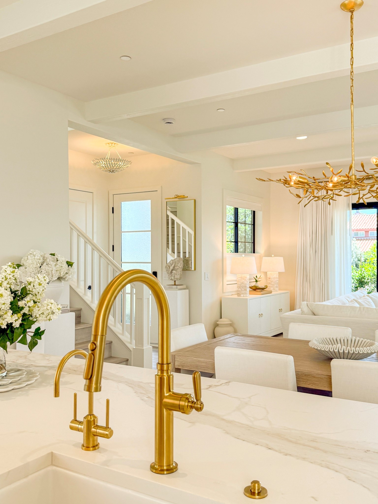 Kitchen Brass Faucet love! 🙌🏼 ❤️
We have been waiting for a custom kitchen faucet for ages that hasn’t arrived yet so we purchased this beautiful Kohler Studio McGee faucet to use in the interim. We have come to fall in love with it . 👏🏼 
If I had known how well this faucet works and how beautiful this faucet was from the start, I never would have ordered the other faucet. 
The finish on this piece is ‘Vibrant Brushed Modern Brass’ and it matches the hot & cold water filter tone of the Graff faucet next to it perfectly. We love it! 

Dining table: Restoration Hardware 
Paint color: SW Alabaster
Countertops: Bedrosians Calacatta Superwhite porcelain in the Matte finish. 
Drapery & Roman Shades: From www.thewindowstylist.com. If you live in Southern California Tania will come to your home and help you! @designs_by_tania on IG

#LTKHome