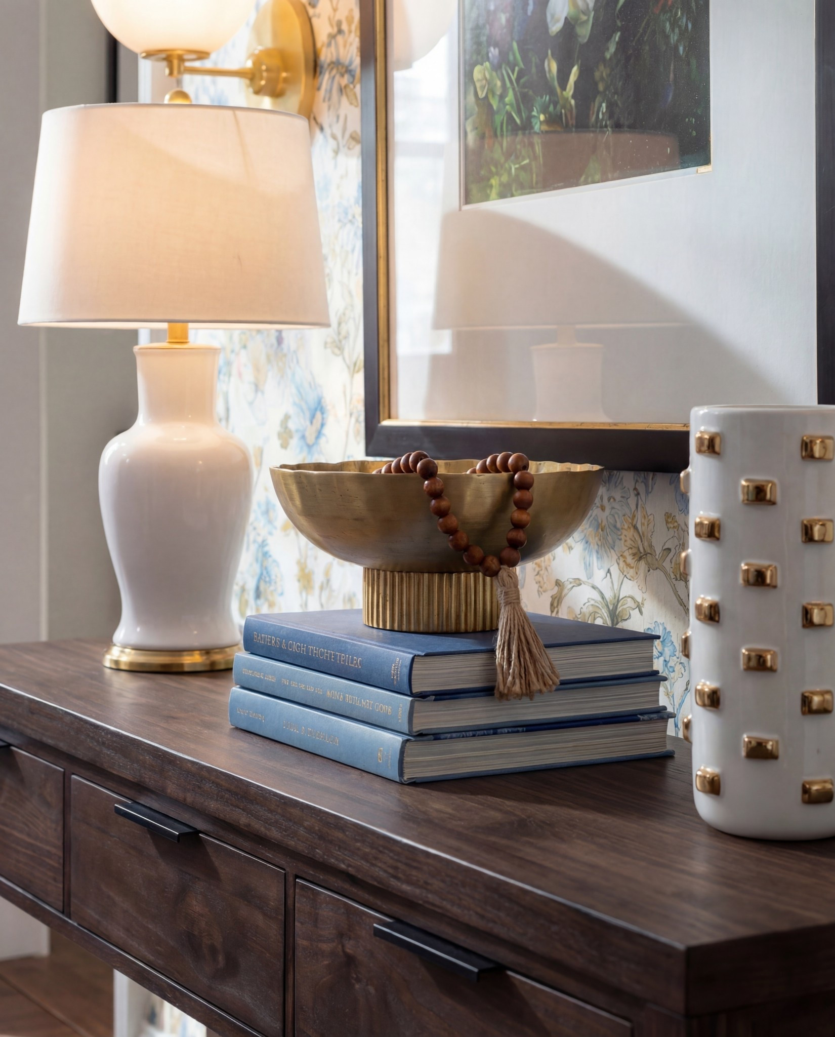 Shop the Look:
• Dark wood console table
• Blue + gold floral wallpaper
• Chunky woven poufs (cool grey)
• Brass globe sconces
• White ceramic table lamp
• Gold decorative bowl
• White studded ceramic vase
• Blue vintage-style runner
• Coffee table books (blue spines for color continuity)
- brown wood decor beads 

#LTKSaleAlert #LTKFindsUnder100 #LTKHome