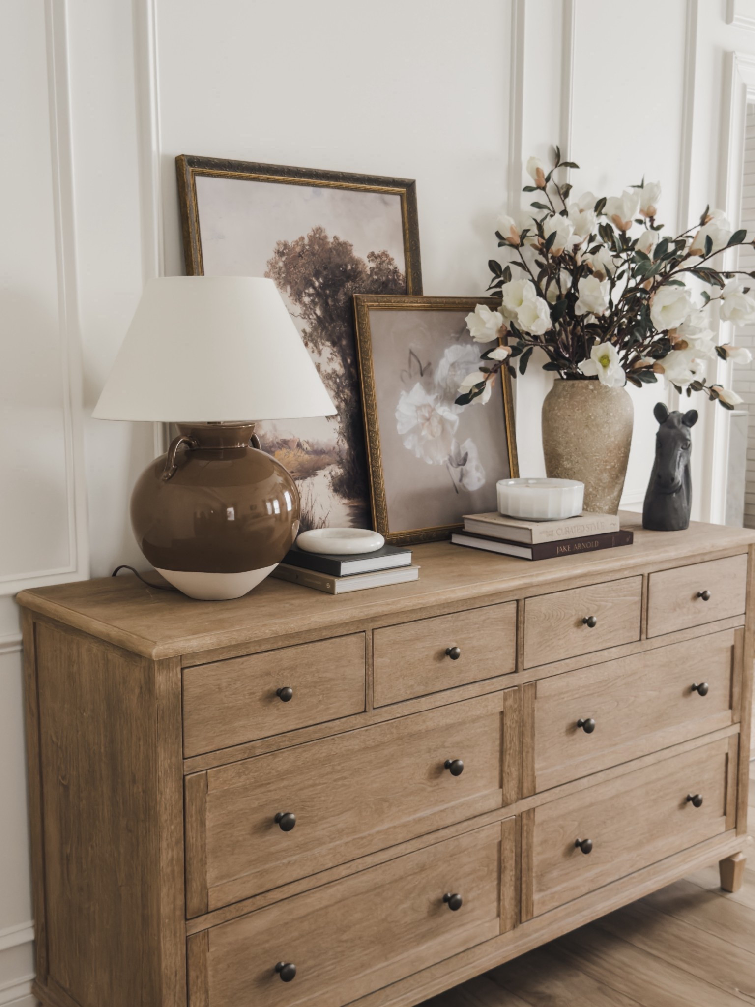 Not as often seen but I often get asked - what is across from your bed? Loving my neutral wood tone dresser that has held up for several years and a move across the country! Rounding the space off with all of the collected, fall vibes.

Home finds, neutral home inspo, fall refresh, neutral bedroom details, neutral wood tones, dresser favorites, table lamp, fall art, fall faux florals, faux magnolia stems, collected style, neutral decor book, wainscoting detail, Pottery Barn style, McGee and Co, Etsy, look for less, shop the look!

#LTKStyleTip #LTKHome #LTKSeasonal