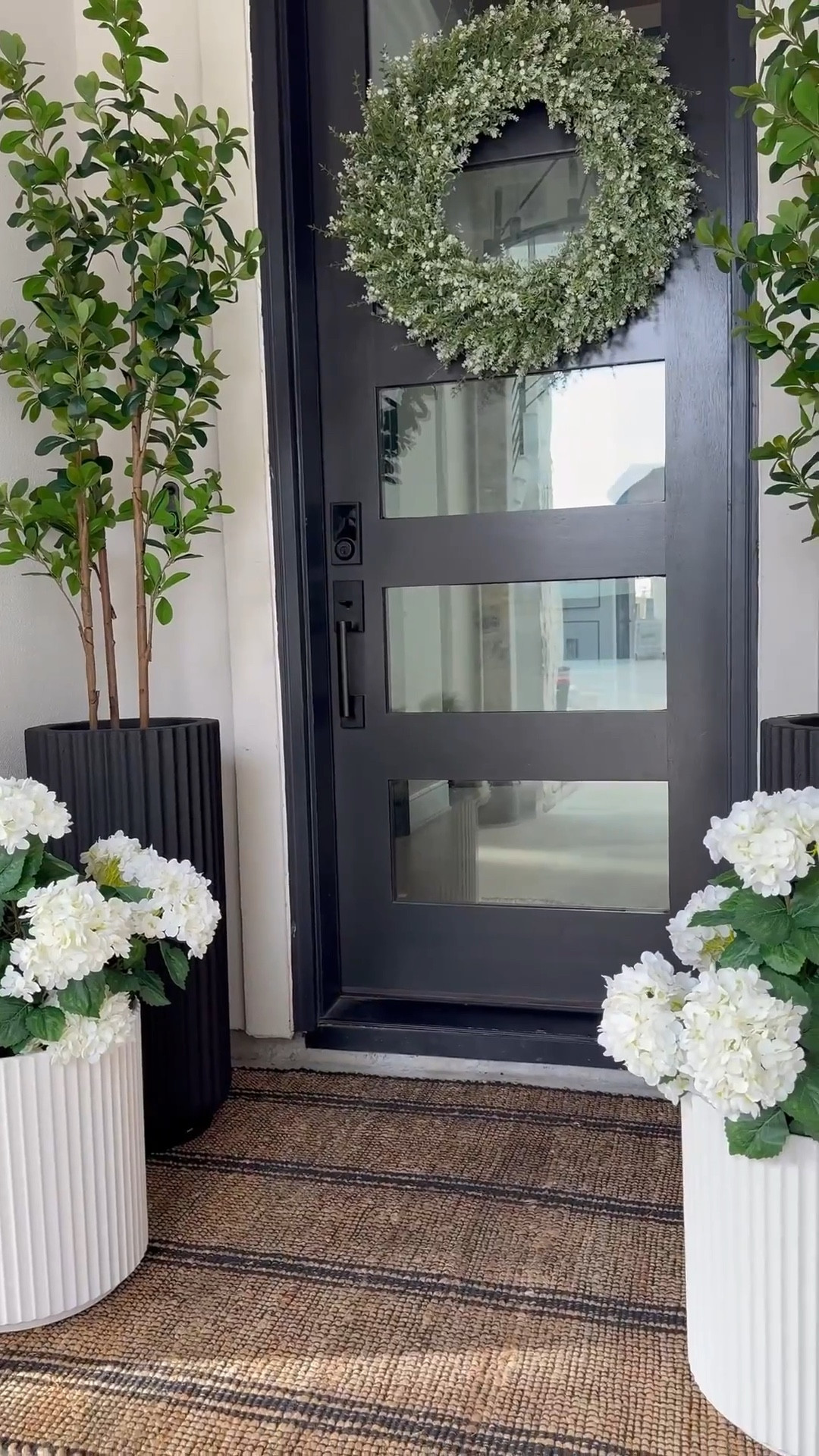 The fluted planters completely stole my heart.....the tall black ones add contrast, the shorter white ones soften everything.🥰

You know I love a black + white foundation 😆 ....& this rug
adds the right amount of warmth. It worked through fall and winter and I already know it'll carry us into summer too.

I layered in hydrangeas (because I can never have too many) 😜 & added small green trees to liven up the space.

And this oversized wreath... such a beautiful statement. This space feels so good!☺️

Create your own space! Click link to shop!

#LTKHome #LTKSaleAlert #LTKSpringSale