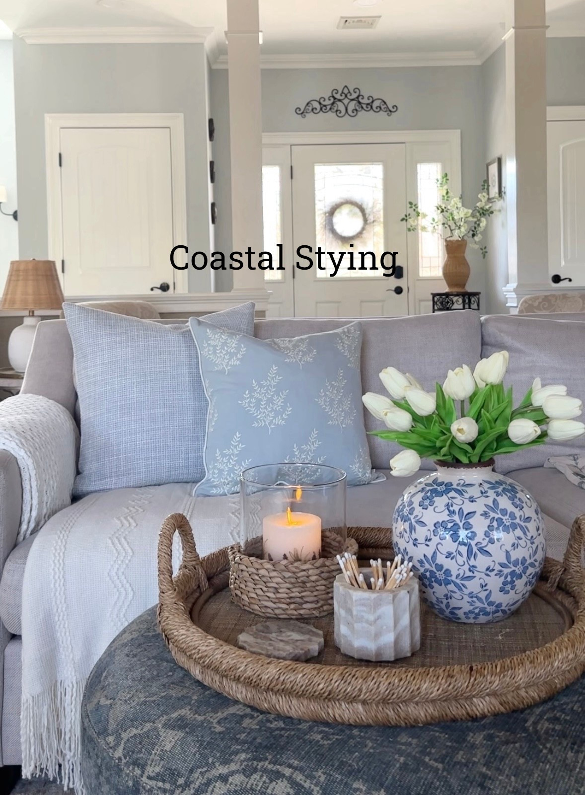 Coastal home styling with pretty blue pillows, favorite vase, tulips, throw blankets, rattan vase, hurricane candleholders, sofa, table lamp, and more home decor accessories ideas. . Pottery Barn, Wayfair, Target, Amazon home. 

#LTKHome #LTKSaleAlert
