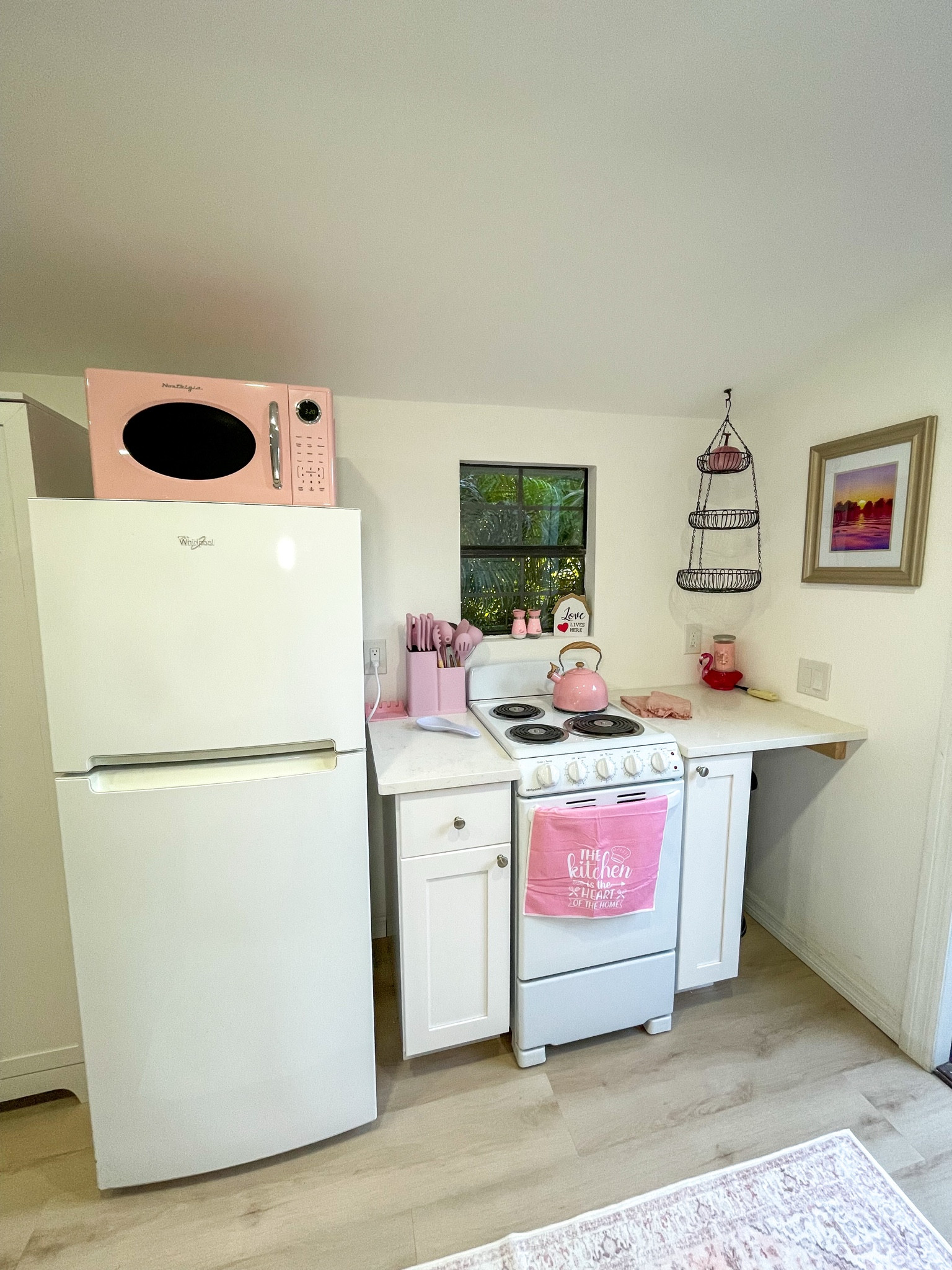 Full kitchen with the dreamiest pink appliances.
