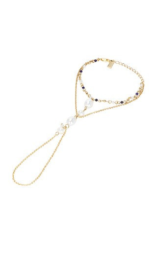petit moments Dune Hand Chain in Metallic Gold. | Revolve Clothing (Global)