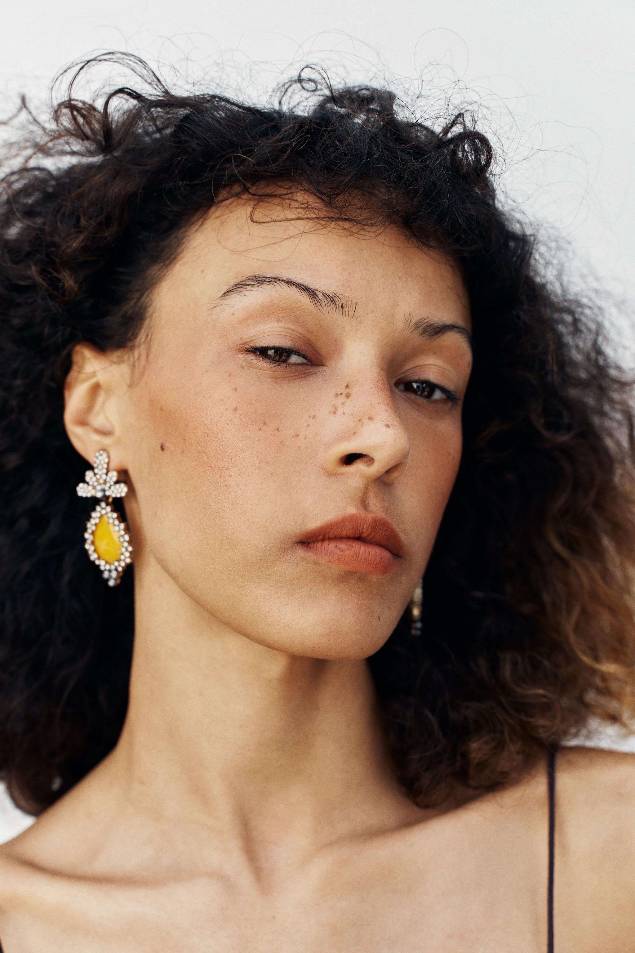 Model height: 174 cmMetal dangle earrings with a set coloured resin stone. Featuring contrasting ... | Zara UK