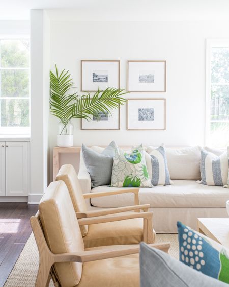 Our Omaha living room decorated for summer! Includes our favorite linen sofas, light leather chairs, blue and white throw pillows, palm tree leaves, light wood gallery frames, a raffia coffee table and long light wood console table! See our full summer home tour here: https://lifeonvirginiastreet.com/2022-summer-home-tour/. .

#ltkhome #ltksalealert #ltkseasonal #ltkfindsunder50 #ltkfindsunder100 #ltkstyletip #ltkfamily#LTKhome #LTKsalealert

#LTKHome #LTKSeasonal #LTKSaleAlert