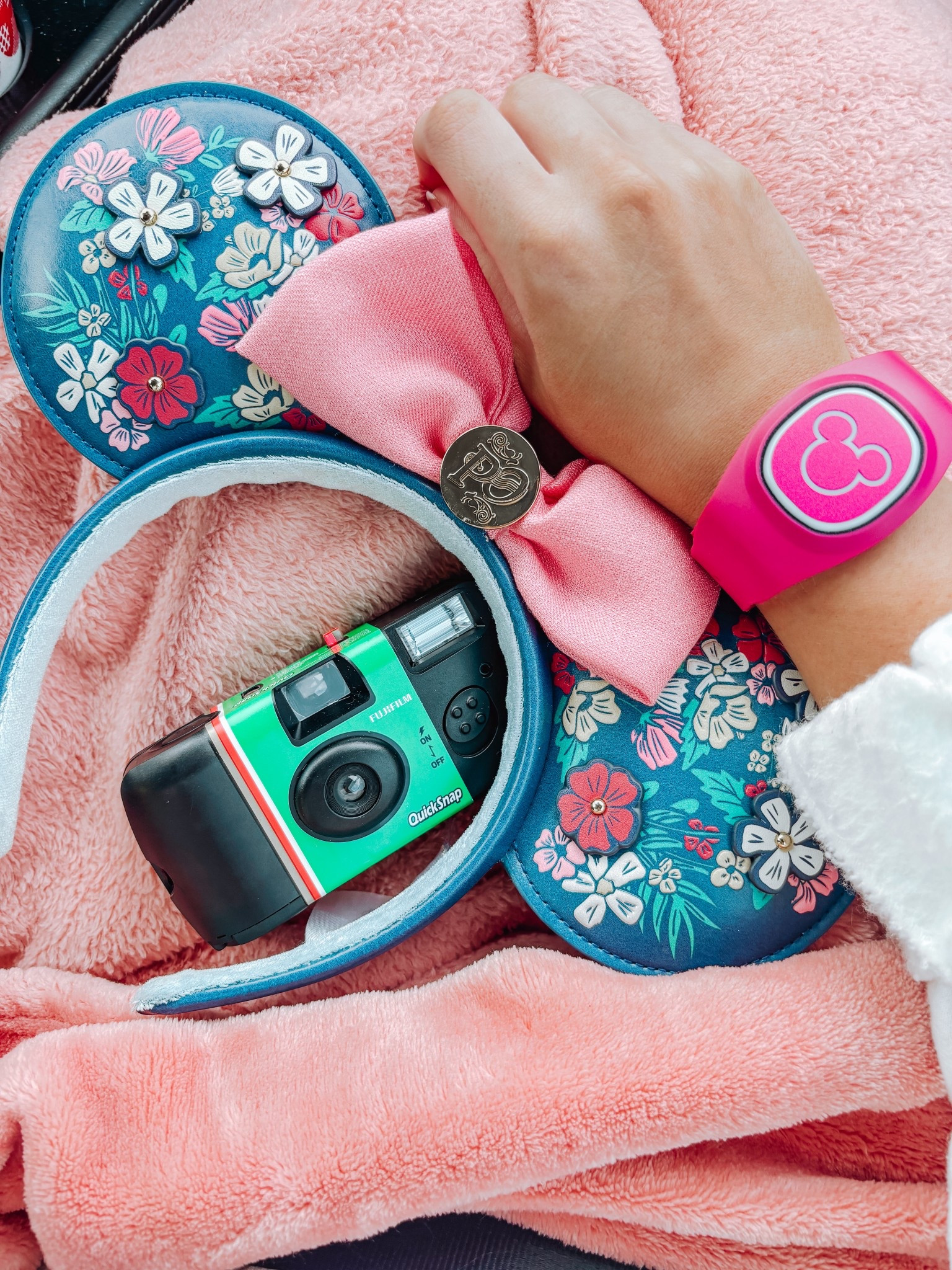 Disney park essentials featuring a pink Magic Band with Mickey icon, Fujifilm disposable camera, and floral Minnie Mouse ears from Port Orleans Riverside Resort. Perfect Disney vacation packing inspiration and theme park must-haves! Get that nostalgic Disney aesthetic with throwback photography vibes. #DisneyWorld #MagicBand #DisneyEars #PortOrleansRiverside #DisneyVacation #DisneyPackingList #FujifilmCamera #DisposableCamera #DisneyAesthetic #ThemeParkEssentials #MinnieEars #DisneyStyle #WDW #DisneyTips #DisneyPhotography #VintageDisney #DisneyParkBag #DisneyAccessories​​​​​​​​​​​​​​​​
