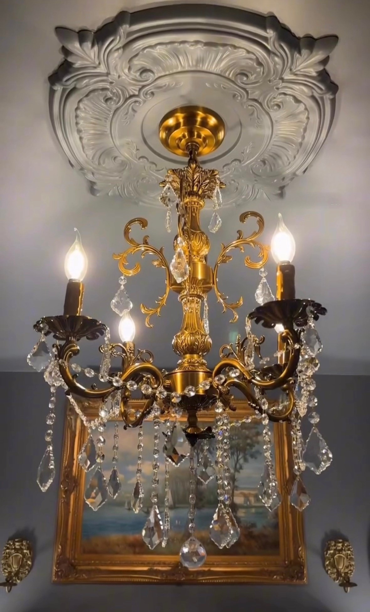 A gold chandelier framed with decorative trim that instantly elevates the ceiling. The layered detail adds depth and elegance, turning the fixture into a true focal point. 

#GoldChandelier #CeilingDetails #TimelessInteriors #StatementLighting #ClassicHome #InteriorStyling #HomeDecor #callsigndesign