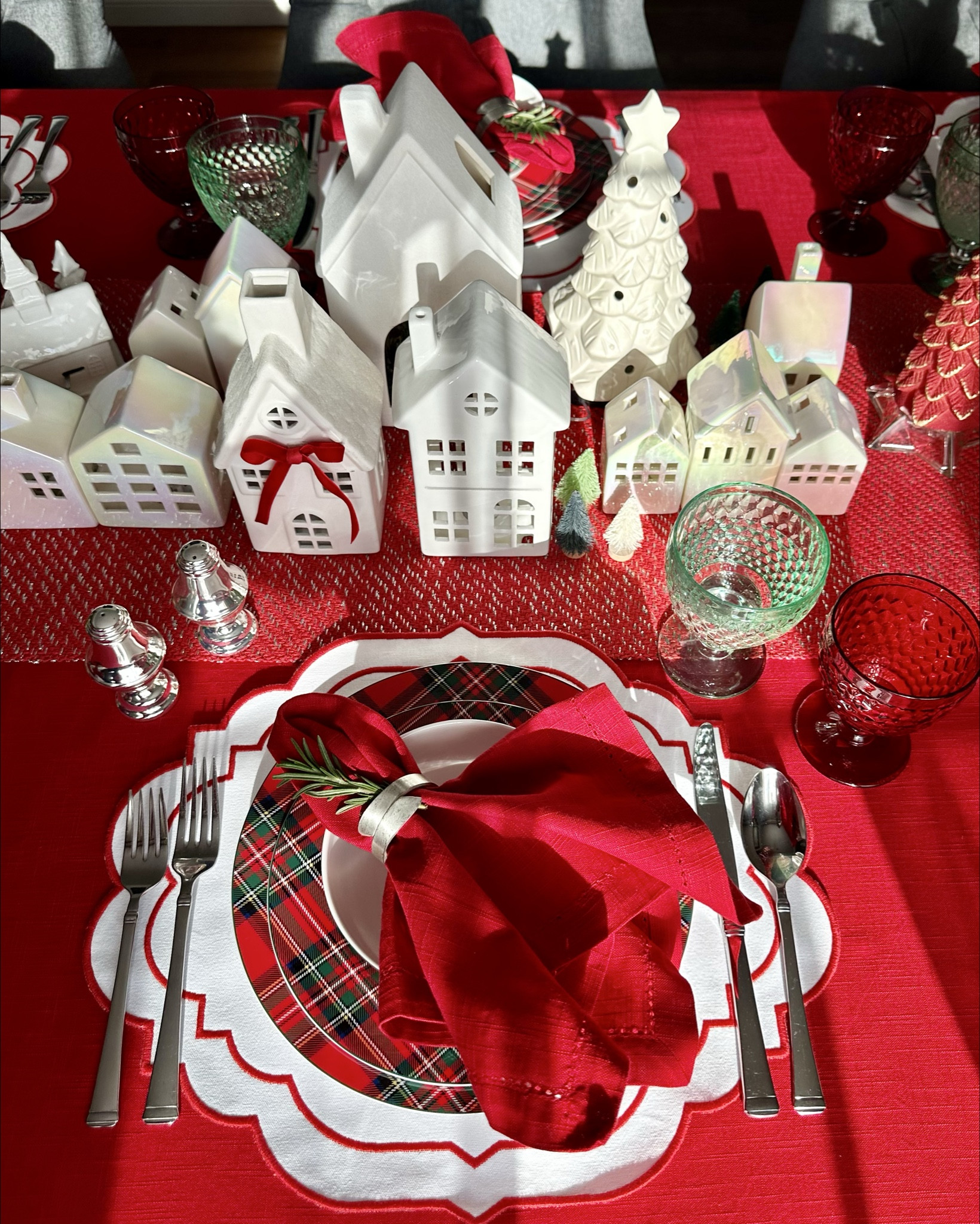 A festive holiday tablescape featuring classic tartan patterns, bold red accents, and a charming ceramic village centerpiece, evoking cozy Christmas charm. Ready to recreate this look? 

#LTKParties #LTKSaleAlert #LTKHome