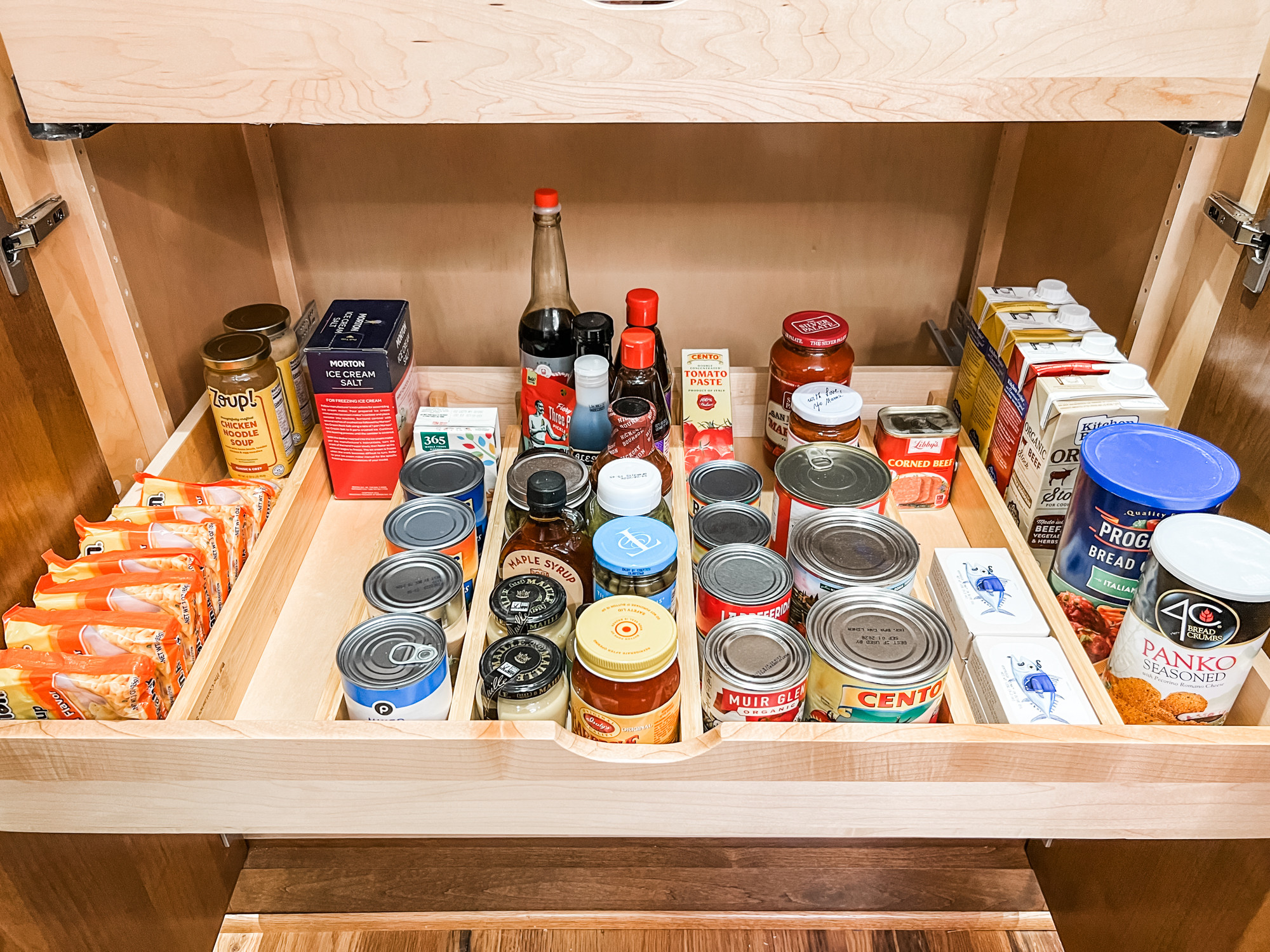 Sometimes clear bins are not the answer in a pantry especially in these wide pull out shelves. In this case, tension dividers work super well to keep like things corralled. 

 