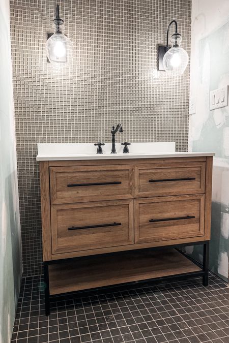 Progress photo of the basement bathroom! Absolutely love this budget vanity, and wall sconce that are both on sale! The faucet is fab too and I have the brass finish in our powder room. 

#bathroomvanity #budgetvanity #wallsconce #budgetsconce #glasssconce #faucet #bathroomplumbing #bathroomlighting

#LTKsalealert #LTKhome #LTKfindsunder100