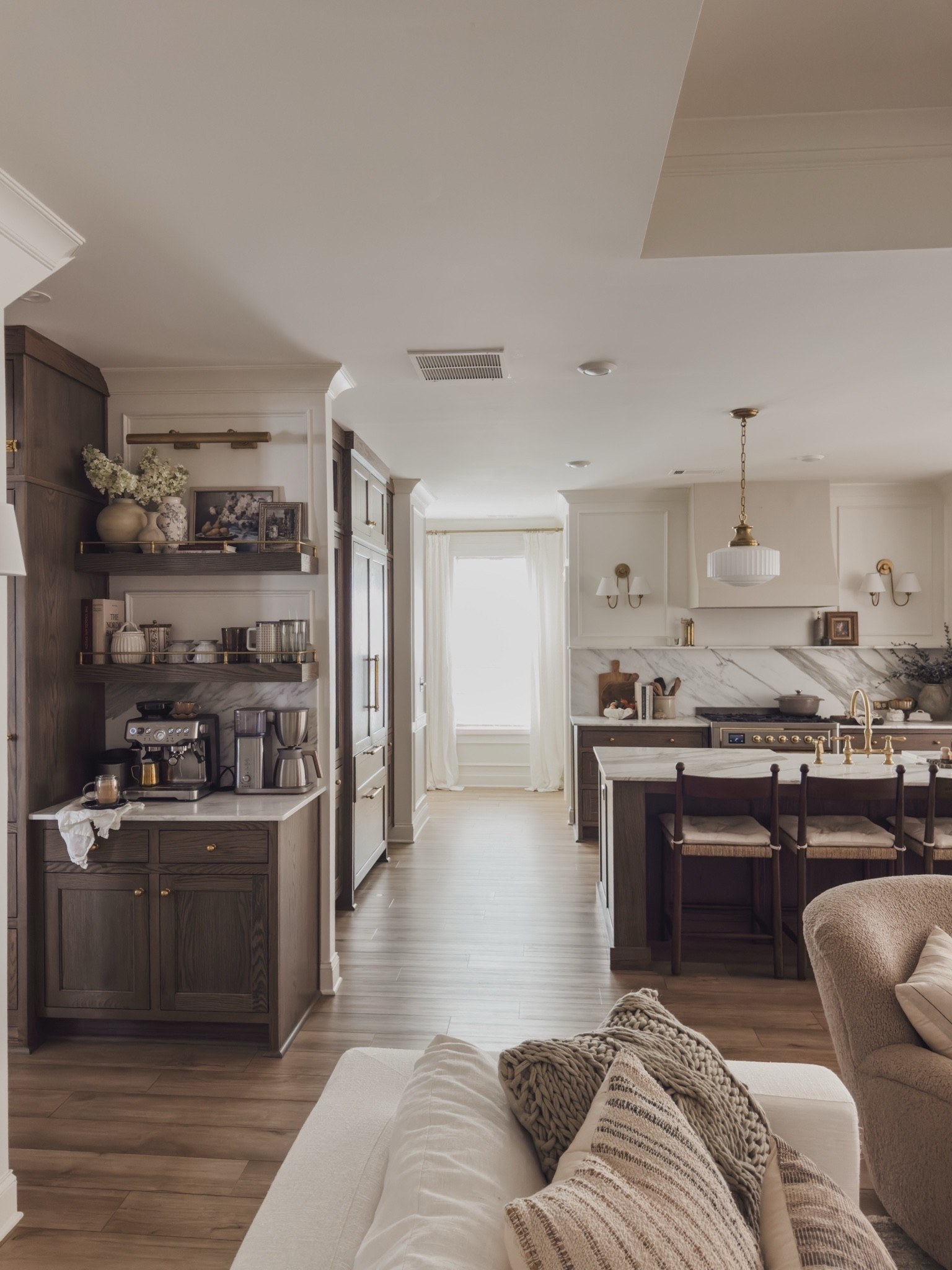 Open concept kitchen views off of the living room! Rich wood tones, creamy whites, and unlacquered brass details for a timeless and collected style.

Home finds, neutral home inspo, kitchen refresh, collected style, timeless home inspo, summer refresh, early fall transition, linen sofa, counter stool, cozy accent chair, coffee bar views, linen curtain, linen shade, gallery rail, pendant lighting, picture light, wall sconces, open concept living, Wayfair, Two Pages, Castlery, Visual Comfort, Four Hands, Pottery Barn style, McGee and Co, Rejuvenation, Home and Kids Co, cozy throw pillow, shop the look!

#LTKSeasonal #LTKHome