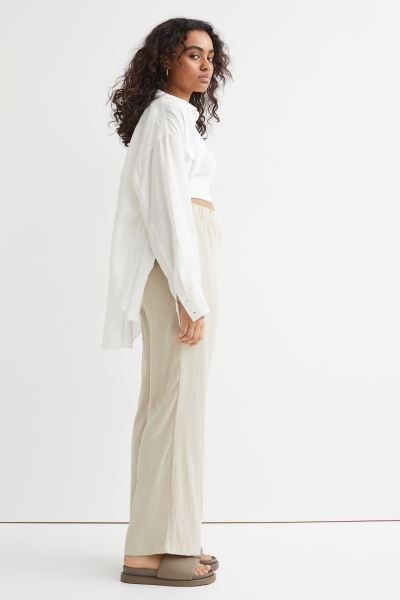 Pants in a woven, crinkled fabric with flared legs. High waist, wide waistband with covered elast... | H&M (US + CA)