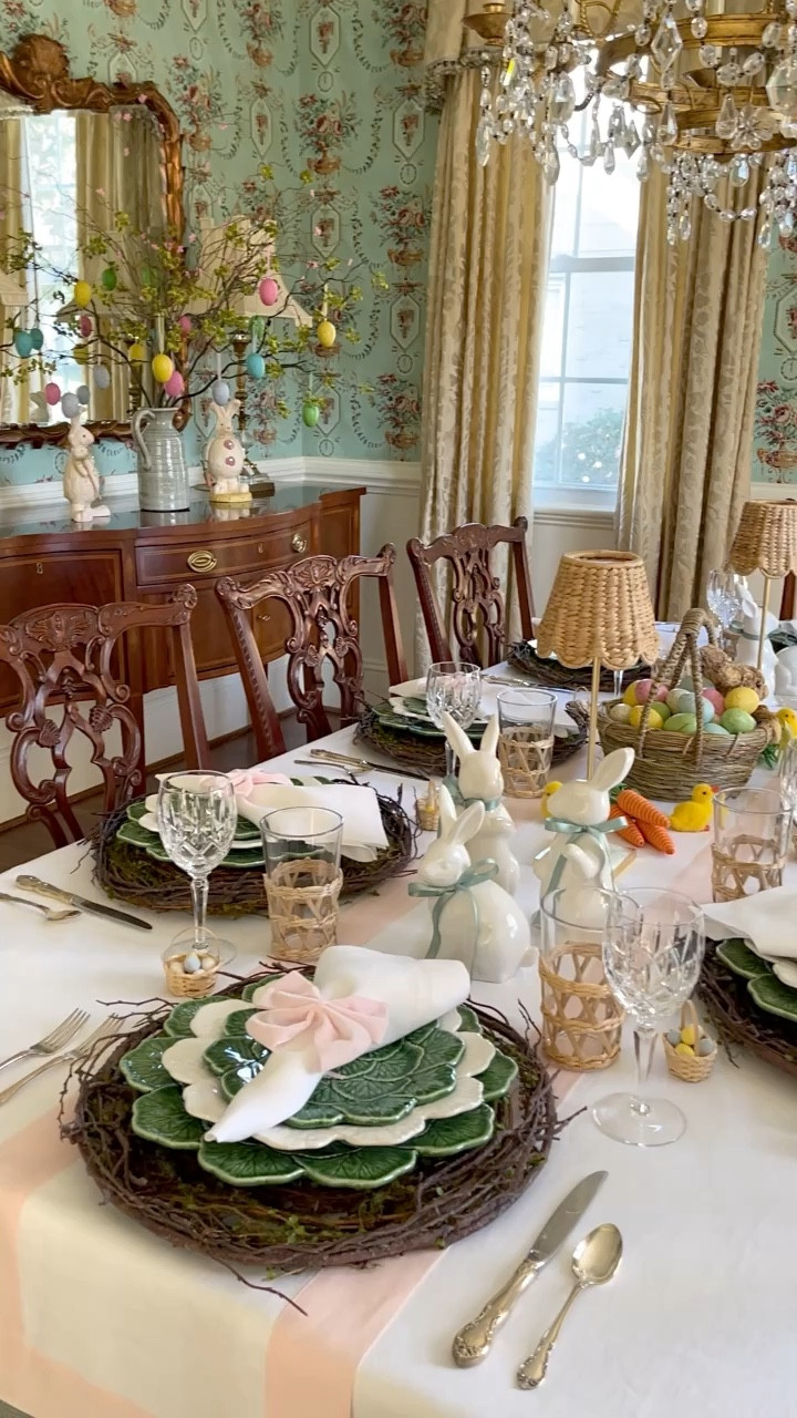 Springing into the season with my first Easter tablescape, and I'm all about blending tradition with a touch of elegance. 🌸🍴As we embrace this lovely season, I'm curious, will you be hosting Easter this year? I've laid down pink and white linens as the perfect backdrop, with grapevine chargers and my favorite green and white tableware paired with shimmering silver flatware for that classic touch. Crystal and rattan glassware add just the right amount of sophistication, while gold leaf table lamps bring  in a chic look. Each plate is topped with a napkin tied in a pink bow, nestled beside adorable white ceramic bunnies sporting light green ribbon neckties, chirpy chicks, rattan carrots, and a Spring bunny basket brimming with colorful Easter eggs for a whimsical twist. 🐰💕 And let's not overlook the buffet area, where Easter bunnies frolic among festive branches in a green ceramic pitcher, beautifully adorned with hanging eggs - truly capturing the essence of celebration. I'd love to hear about your traditions and how you're making this time special! 🌷🍽🐇

#LTKstyletip #LTKSeasonal #LTKhome