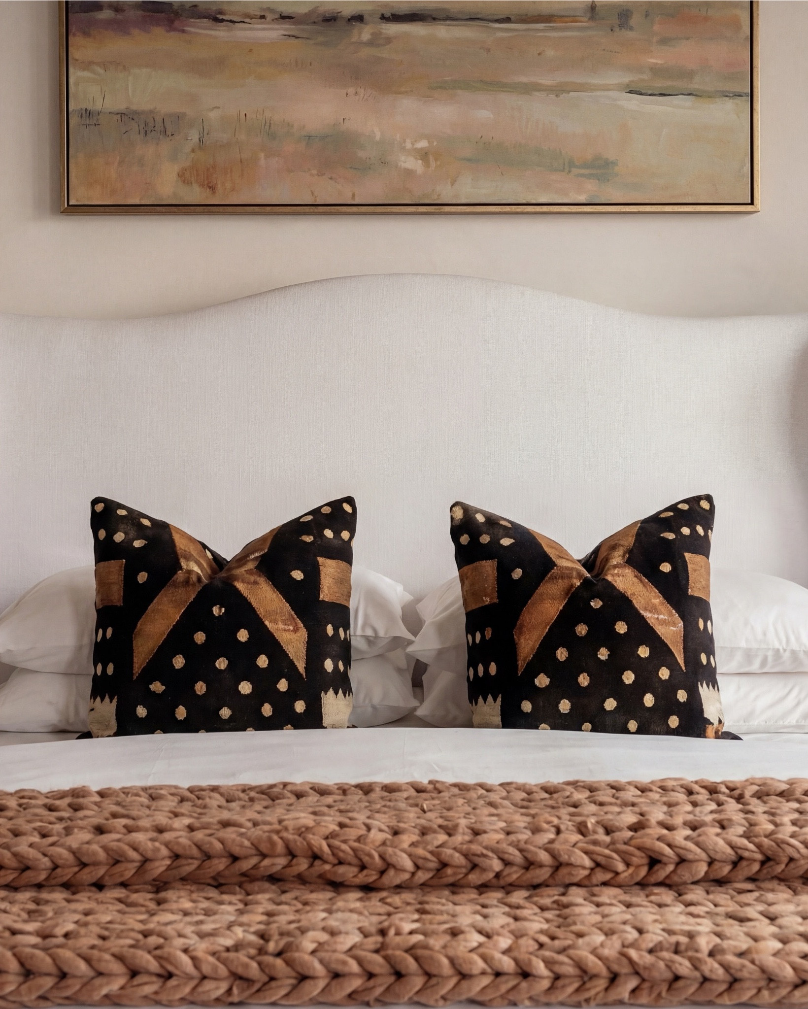 Shop the Look: Bedroom Refresh
This bedroom feels warm, layered, and quietly elevated. Rustic wood ceiling beams bring character and age, while soft neutral upholstery and tailored bedding keep the space feeling polished and calm. Dark wood casegoods ground the room, balanced by creamy textiles, warm brass accents, and subtle pattern throughout. Every detail feels intentional but effortless—classic, timeless, and livable.

The styling leans collected rather than decorated: chunky knits, sculptural ceramics, soft candlelight, and muted artwork that adds depth without overpowering the space.

Shop the Look:
• Upholstered wingback bed (ivory fabric)
• White cotton bedding set
• Neutral euro pillows
• Black and tan patterned accent pillows
• Chunky knit throw blanket (camel brown)
• Dark black wood nightstands
• Decorative bunny Brass table lamps with white shades
• Framed abstract wall art (neutral tones)
• Vintage-style area rug (beige and taupe)
• Dark black wood dresser with brass hardware
• Brass ring drawer pulls
• Glass hurricane candle holders
• White pillar candles
• Decorative brass tray
• Sculptural brass decor object
• Small stone sculpture 
• Light beige linen curtains
• Ceramic vase (off-white)
• Decorative branches
• Coffee table books (neutral covers)
• Upholstered bench at foot of bed (cream fabric)
• Upholstered wood accent chair 
• Round ribbed black end table

#LTKhome #LTKsale #LTKstyletip