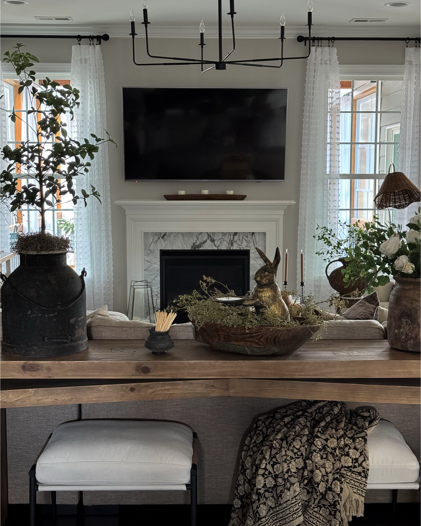 Friday Photos of Home Lately!!

Console table, ottomans, floral throw blankets, cabbage roses, greenery, vintage wood vase, woven vase, chandelier, diamond print rug, woven lamp shade, upholstered chair, floor lamp with woven shade, floral throw pillow, round coffee table, antique gold rabbit snuffer, pineapple candle snuffer, magnifying glass, black metal candle holders, woven storage boxes, pussy Willow, black vase, crystal selenite sticks, dipped leg stool