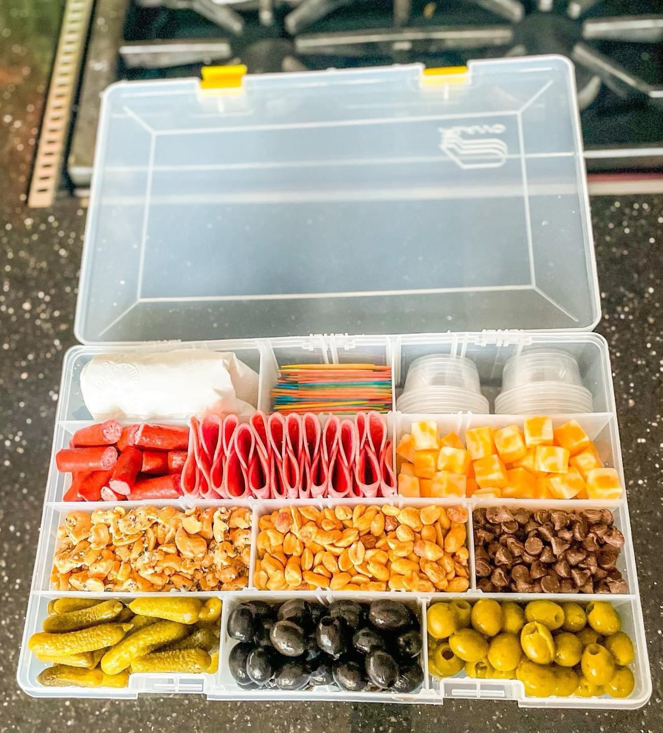 We’re ready for a day out on the water with this fun “snackle box”! This is the perfect box for all the snacks! It comes with removable dividers, so you can make as many or as few compartments as you want (between 4-15)! The latches close tightly on the front so this can be placed inside a cooler without spilling. 