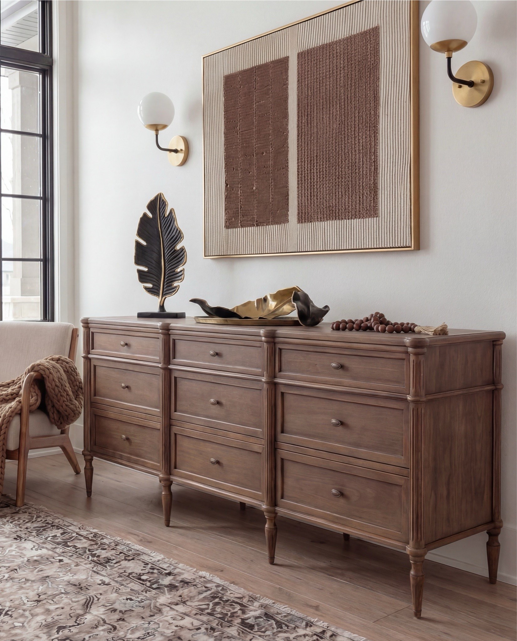 Shop the Look: Bedroom Refresh
• Upholstered bed frame (light neutral fabric)
• White cotton duvet cover + pillow shams
• Neutral patterned area rug
• Chunky knit throw blanket (warm beige)
• Woven knit poufs (foot-of-bed seating)
• Dark wood nightstands with brass pulls
• Sculptural white ceramic table lamps
• White tapered lamp shades
• Brass-framed rectangular mirrors
• Framed floral artwork (warm, moody tones)
• Neutral linen accent pillows
• Ceramic decorative bowl (white sculptural style)
• Small glass vase with white florals
•Dark wood dresser
•wood upholstered accent chair 
•brass tray
•black leaf decor
•brown wall art
•round wall sconce 
•wood decor beads 

#LTKHome #LTKSaleAlert