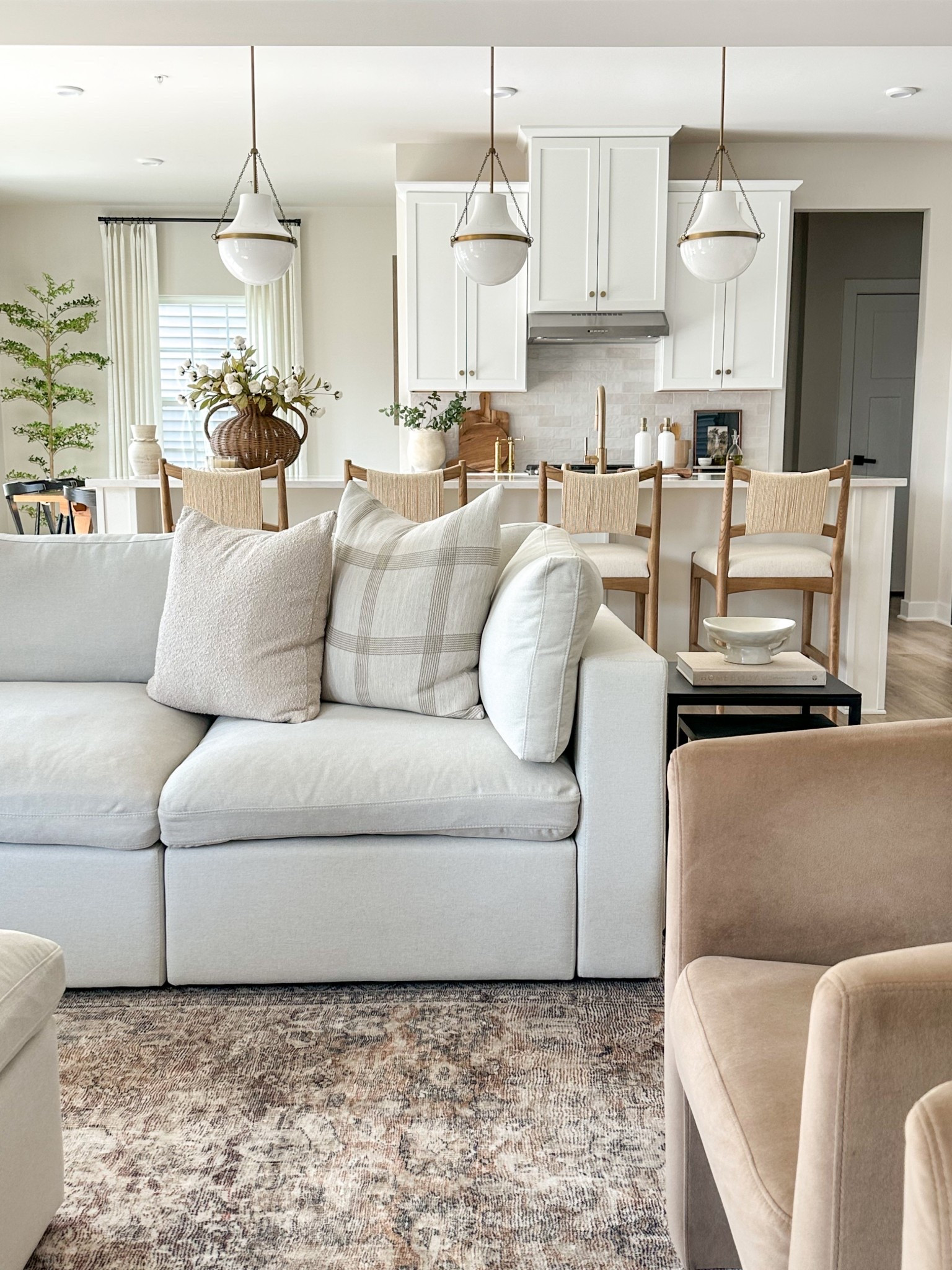 Warm, layered, and timeless living room and kitchen. 
#livingroom #kitchen #rug #pendants #counterstools #nestingtables 

#LTKHome #LTKSaleAlert