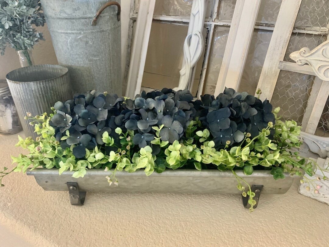 Refresh your space with this beautifully styled galvanized planter centerpiece by CountryHomeandHeart. Filled with lush greenery and soft hydrangeas, this versatile piece adds the perfect farmhouse touch to your table, mantel, or kitchen island. With customizable flower options and colors, you can create a look that fits your home perfectly—bringing effortless charm and seasonal beauty year-round. #LTKHome #FarmhouseDecor #HydrangeaLove #TableCenterpiece #RusticStyle #HomeStyling #NeutralDecor #CozyHome

#LTKHome #LTKSeasonal