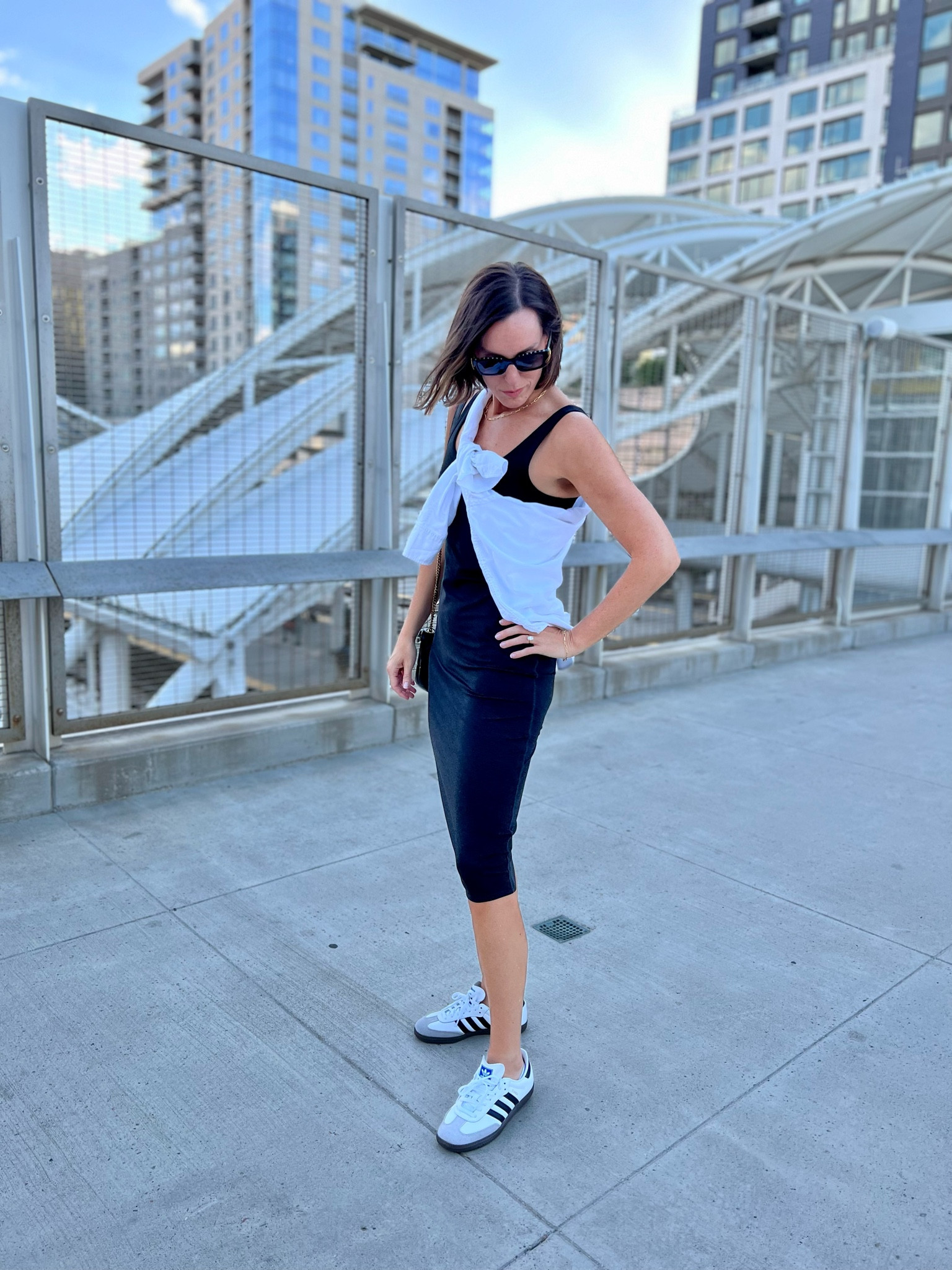 Summertime in the city! Simple, sporty chic outfit idea. Black tank dress, white sneakers - love those Adidas sambas! A beautiful bag and classic sunglasses. I did the crossbody shirt tie with my classic white button-down. Doubles as a cool accessory piece, and also a layer for when it cools down. Easy, classic, comfortable look!

#LTKstyletip #LTKSeasonal
