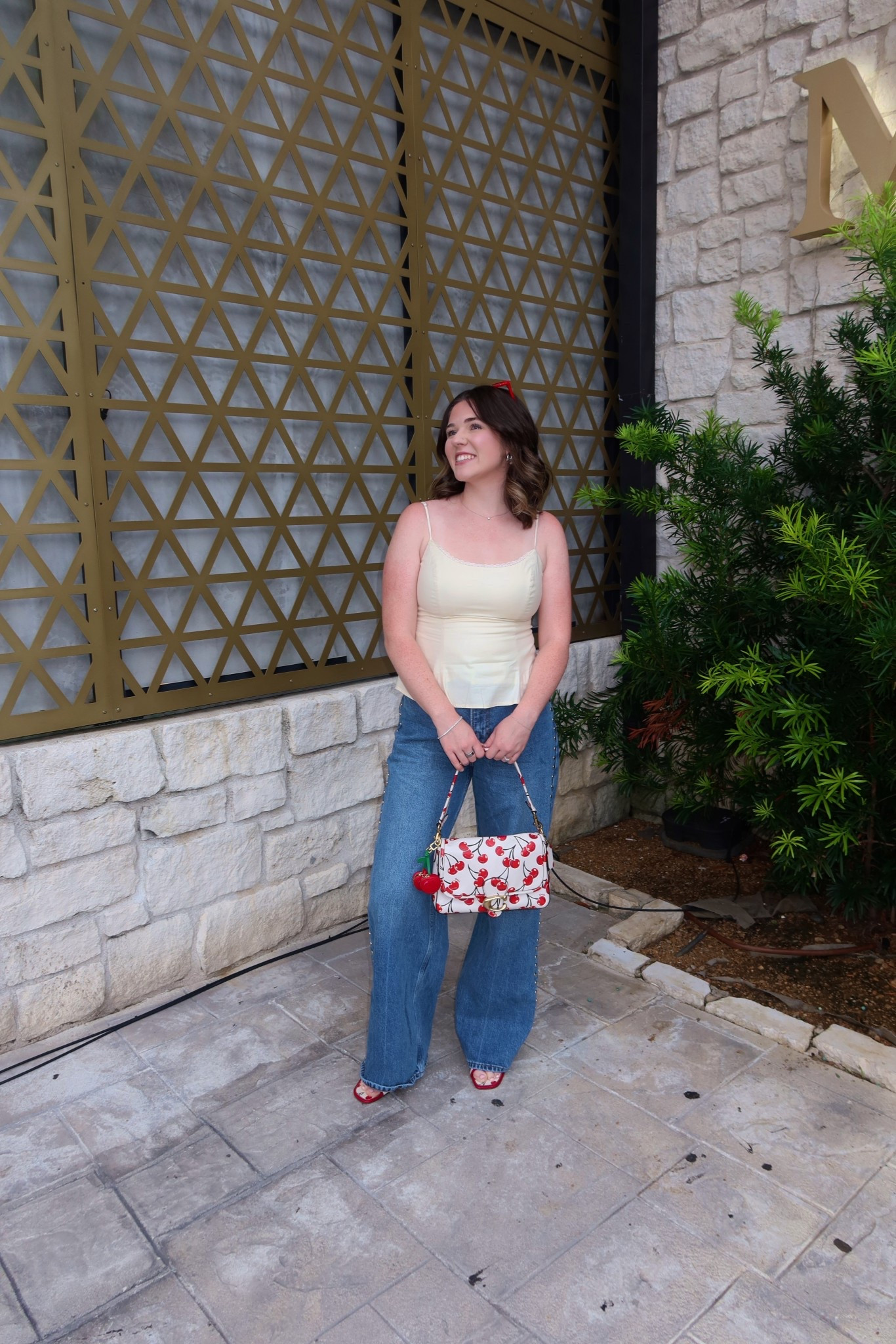 Date night outfit 
Reformation yellow tank 
Reformation studded jeans 
Cherry coach purse and shoes 
Red sunglasses 

#LTKShoeCrush #LTKParties #LTKStyleTip