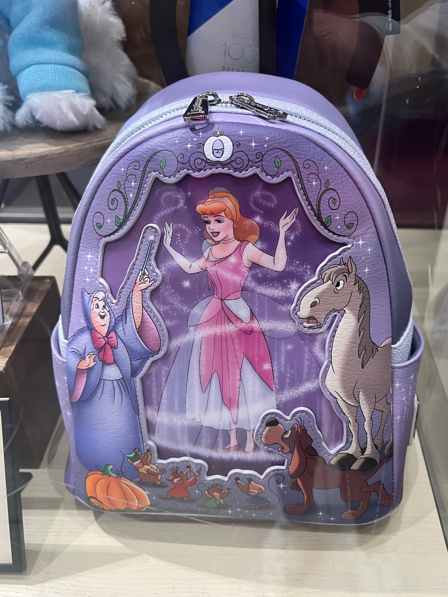 New loungefly backpack Cinderella Disney 100 year celebration. The dreams that you wish can come true when carrying this Loungefly mini backpack inspired by Walt Disney's animated classic Cinderella. A dazzling inset front panel changes our heroine's appearance from rags to riches like magic, while her Fairy Godmother and animal friends look on in amazement.

Magic in the details
Simulated leather mini backpack
Fairy Godmother, Bruno, Major, Jaq, Gus, Luke and Bert screen art
Cinderella inset changes from rags to ballgown
Back features Pumpkin Coach and castle
Silver simulated leather ''Disney 100 Decades'' label on back
Double zipper main compartment
Side slip pockets
Loungefly logo metal pulls
Silvertone hardware
Adjustable padded shoulder straps
Top carry handle
Print lining features Gus, Jaq, Luke, Bert and pumpkin
Disney x Loungefly logo label plate
Inspired by Walt Disney's Cinderella (1950)
Part of the Disney100 Decades: The 1950s Collection
Part of the Disney100 Celebration Collections


#LTKGiftGuide #LTKFind #LTKSeasonal
