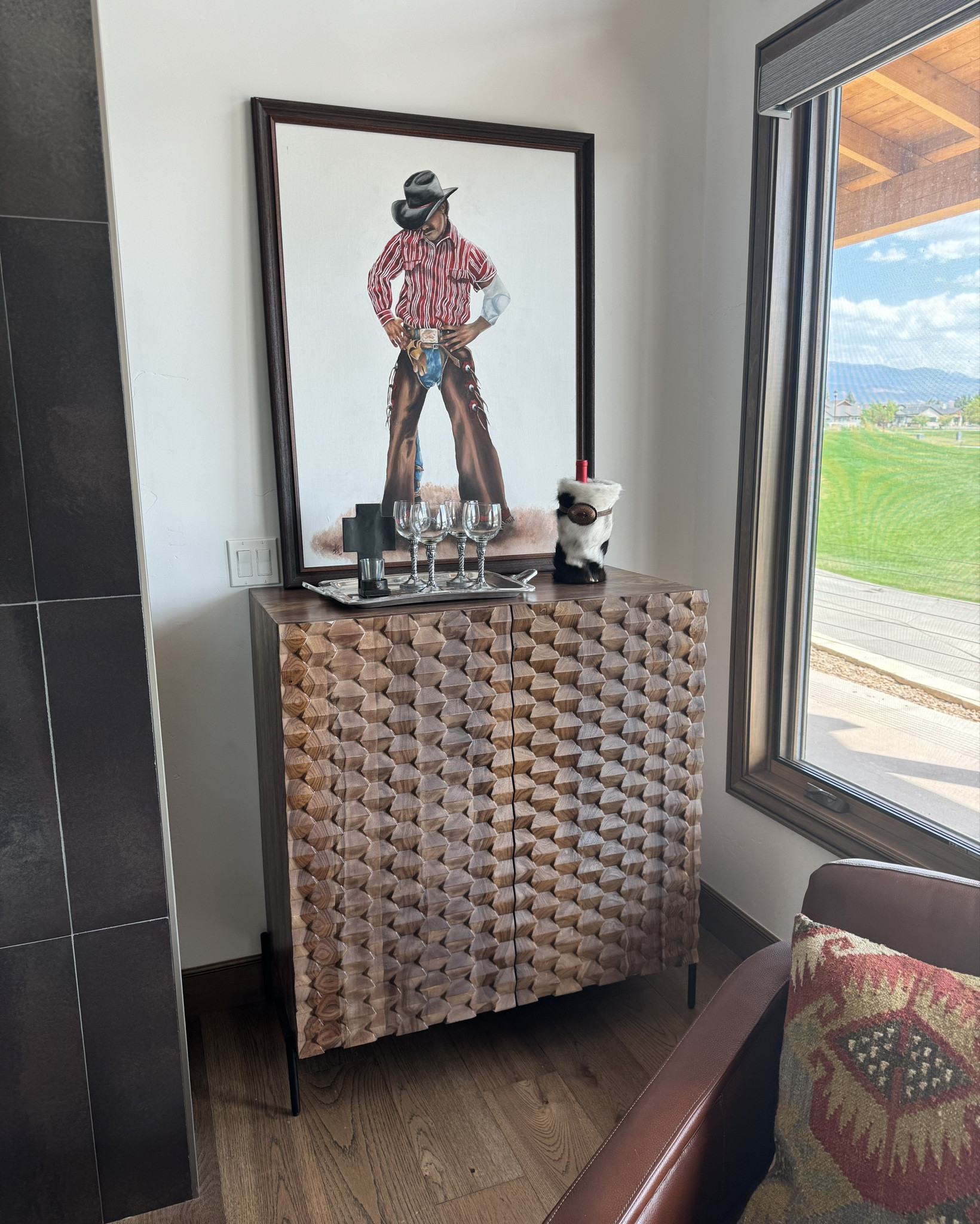 43” H X 39” W Bar cabinet. 
Black powder coated iron legs
wood is magnificently finished in brown with raised a geometric design across the two doors, this bar cabinet has places for everything you want to keep at hand. Racks for your stemware, bottle storage racks, plus two shelves keep items close, but out of sight. For your family room, den, or kitchen, this bar cabinet will be an addition that you will wonder how you ever did without.
Entertaining unit, bar furniture 
Mountain modern. 
Wine glasses, cow hide wine holder
Pewter tray

#LTKHome