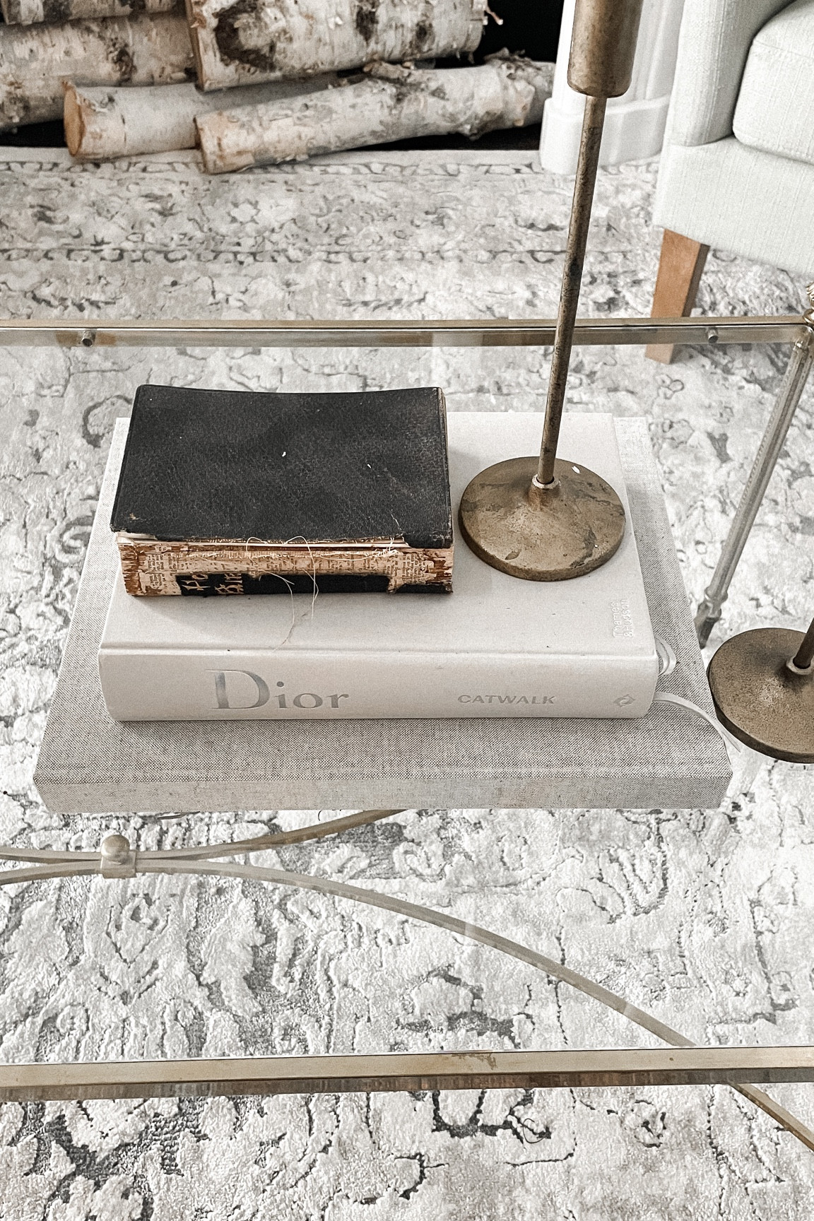 Coffee table styling 
Candle holders 
Coffee table books 
Gold glass coffee table 
White birch logs 
Vintage area rug 

#LTKFind #LTKhome #LTKstyletip