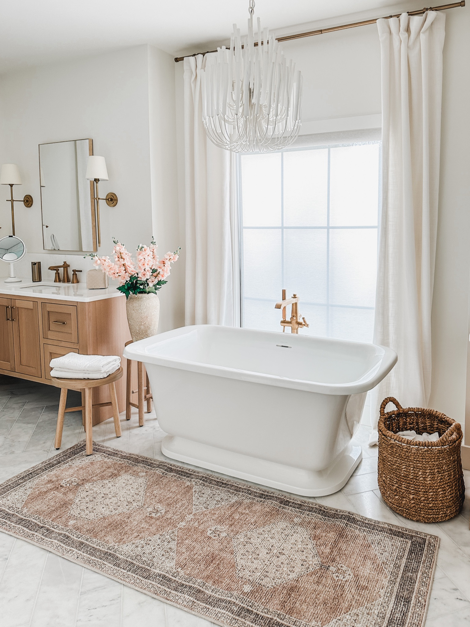 Light and area, open concept, bathroom with double vanities, and a freestanding tub. Styled with creamy whites, warm tone, words and pops of pink! 

#LTKhome #LTKsalealert #LTKstyletip