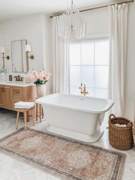 Light and area, open concept, bathroom with double vanities, and a freestanding tub. Styled with creamy whites, warm tone, words and pops of pink! 

#LTKhome #LTKsalealert #LTKstyletip