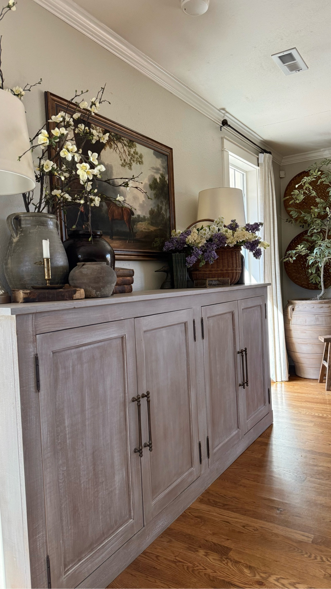 🌿 The sideboard that feels like it was collected across a lifetime of European travels.
Vintage equestrian prints. Antiques mixed with beautifully sourced finds. Crocks, pottery, and storied little touches that feel like they came from a Paris flea market or a Provence farmhouse. 🏇🤍
And then — the lilacs. A French basket overflowing with the most realistic stems, sprayed with actual lilac fragrance. The moment you walk in the room, you know. 🌸
Layered. Lived in. Completely collected. This is the vignette that makes your home feel like a story. ✨


#LTKSpringSale #LTKHome #LTKSeasonal