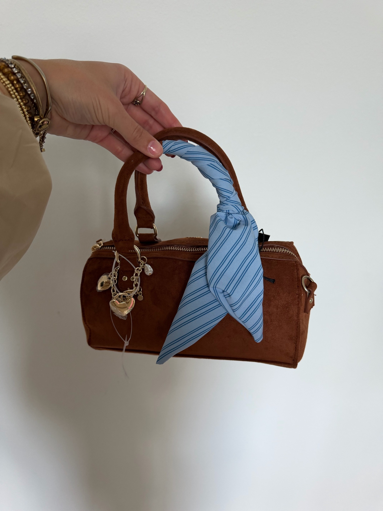 The Madde NYC Small Top Zip Faux Suede Handbag—crafted in a soft faux suede for a chic look, this baguette-silhouette handbag tucks neatly under your arm like it’s meant to be there. Running late? Clip on the crossbody strap and go hands-free? Feeling stylish? Add the scarf, let the keychains swing, and your look is now complete. With a top zip to secure the essentials, this handbag is a versatile choice for any type of day.

#LTKootd #LTKSeasonal #LTKdayinmylife