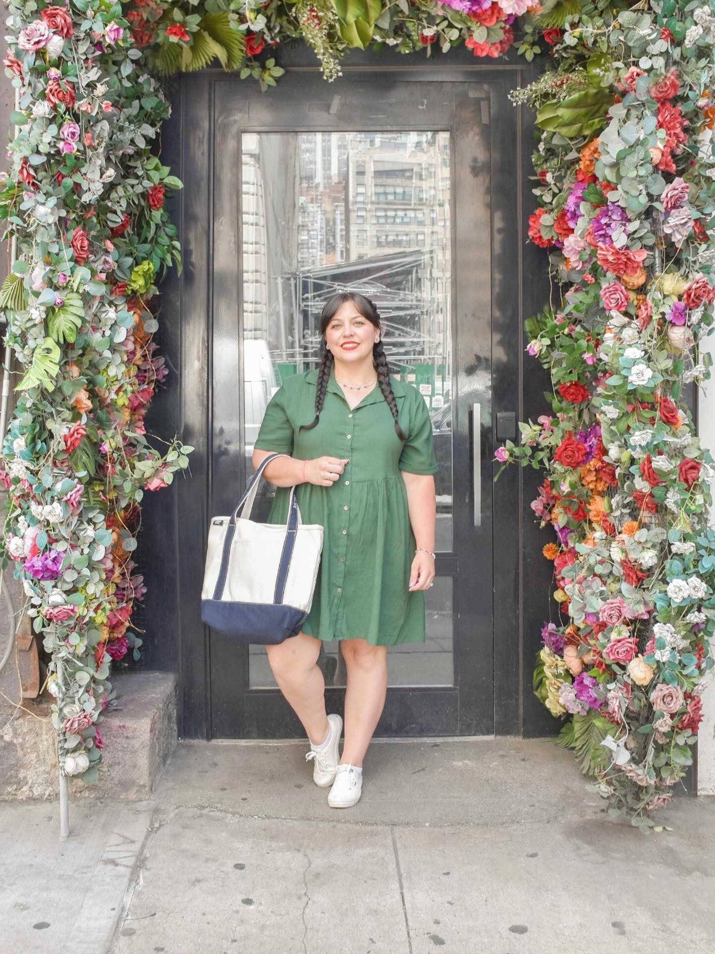 sundress +  keds season ☀️🤍 found myself a floral arch and couldn’t resist - florals for spring? groundbreaking 💄 but when you’re in the city you take the photo op! I got this cute bag at an event we went to and they embroidered it with MOM for me 🥹 perfect for all our summer adventures! now that the warm weather is here (and me and postpartum are getting along better 🤣😅) I’ll have plenty of places to tell you about and cute easy outfits to share 👏🏻 

comment DRESS for a link to this dress and similar throw on and go styles 🫶🏻 #momstyle #midsizestyleinspo #summerdresses