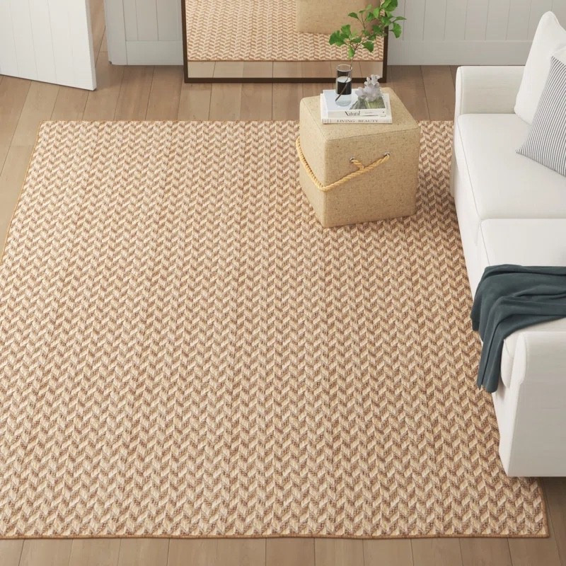 This herringbone indoor/outdoor rug from Wayfair is the perfect neutral base for any space. With its warm brown and tan tones, it adds texture and depth while pairing beautifully with a white sofa, wood flooring, and natural decor. 