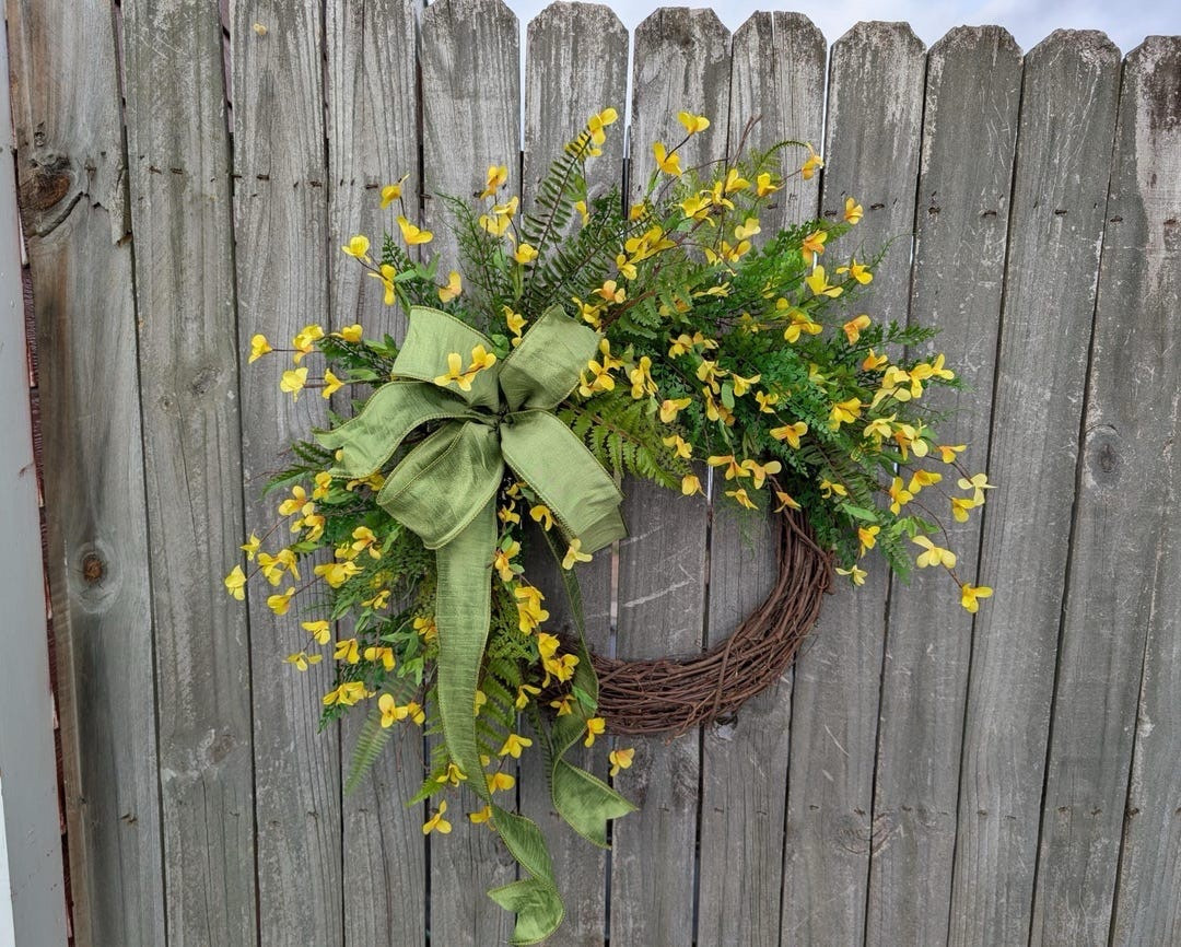Brighten your front door with this cheerful Forsythia wreath from HornsHandmade. Featuring vibrant yellow blooms, airy greenery, and a soft green wired bow, this wreath brings fresh spring and summer charm to any space. Designed on a natural grapevine base with realistic PVC fern and silk florals, it offers a light, natural look that’s easy to refluff and enjoy year after year. Available in multiple sizes, it’s perfect for front doors, double doors, or adding a sunny welcome to your home.

#LTKHome #LTKStyle #SpringWreath #FrontDoorDecor #ForsythiaWreath #SpringDecor #FarmhouseDecor #SeasonalDecor #HomeDecorInspo #YellowDecor #PorchDecor #SummerDecor #WreathDecor

#LTKWedding #LTKSeasonal #LTKHome