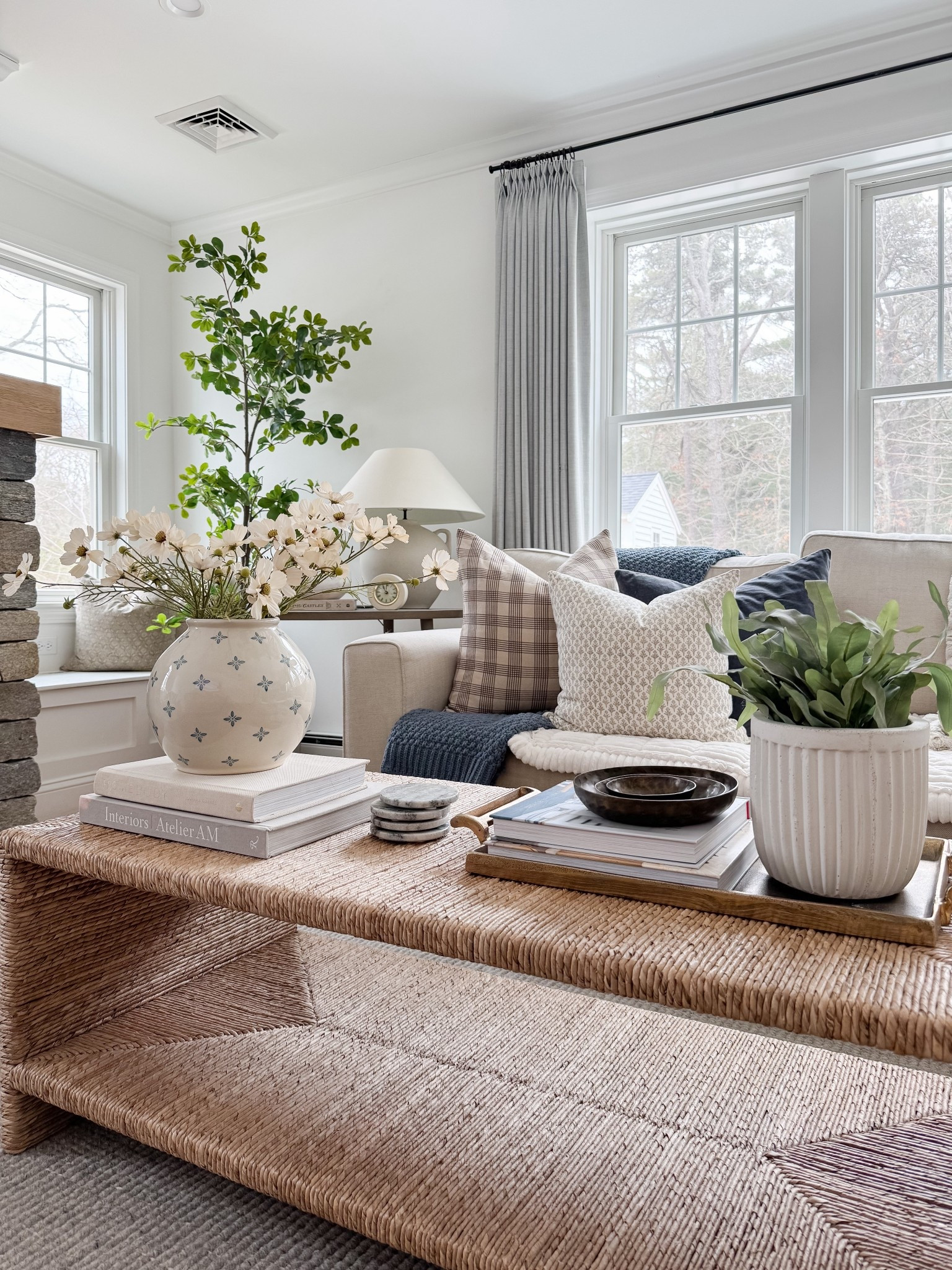 Bright neutral living room with woven coffee table, ceramic vase with greenery branches, linen drapery panels, and soft textured pillows. Natural light, organic materials, and warm wood tones bring a relaxed coastal feel. 
woven coffee table, neutral coastal decor, linen curtains, living room inspiration, spring home refresh, natural textures, ceramic vase decor, greenery stems, light filled living room, warm wood tones, coastal style, organic modern, sherri calnan home

#LTKHome