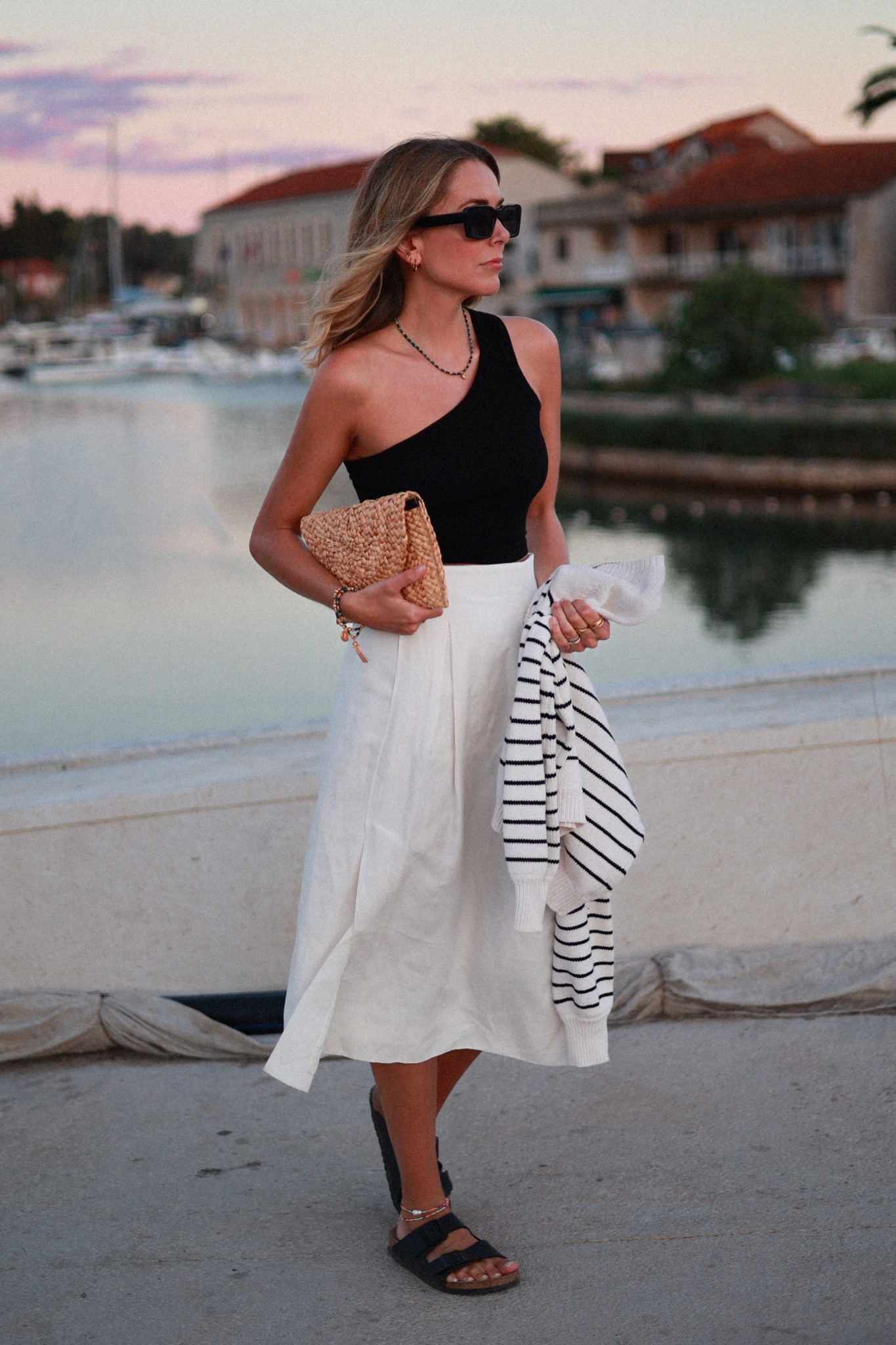 Knitwear 
Stripe knit 
Midi skirt 
Cos skirt 
Sezane 
Straw clutch 
One shoulder top 

#LTKeurope #LTKtravel #LTKSeasonal